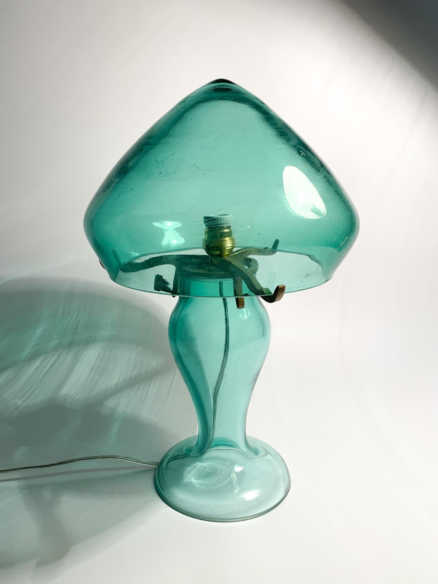 Mushroom-shaped table lamp in hand-blown green Murano glass, the creation of which is attributed to Archimede Seguso in the 1960s. The electrical system has been replaced with a new one. 

Ø 19 cm h 32 cm