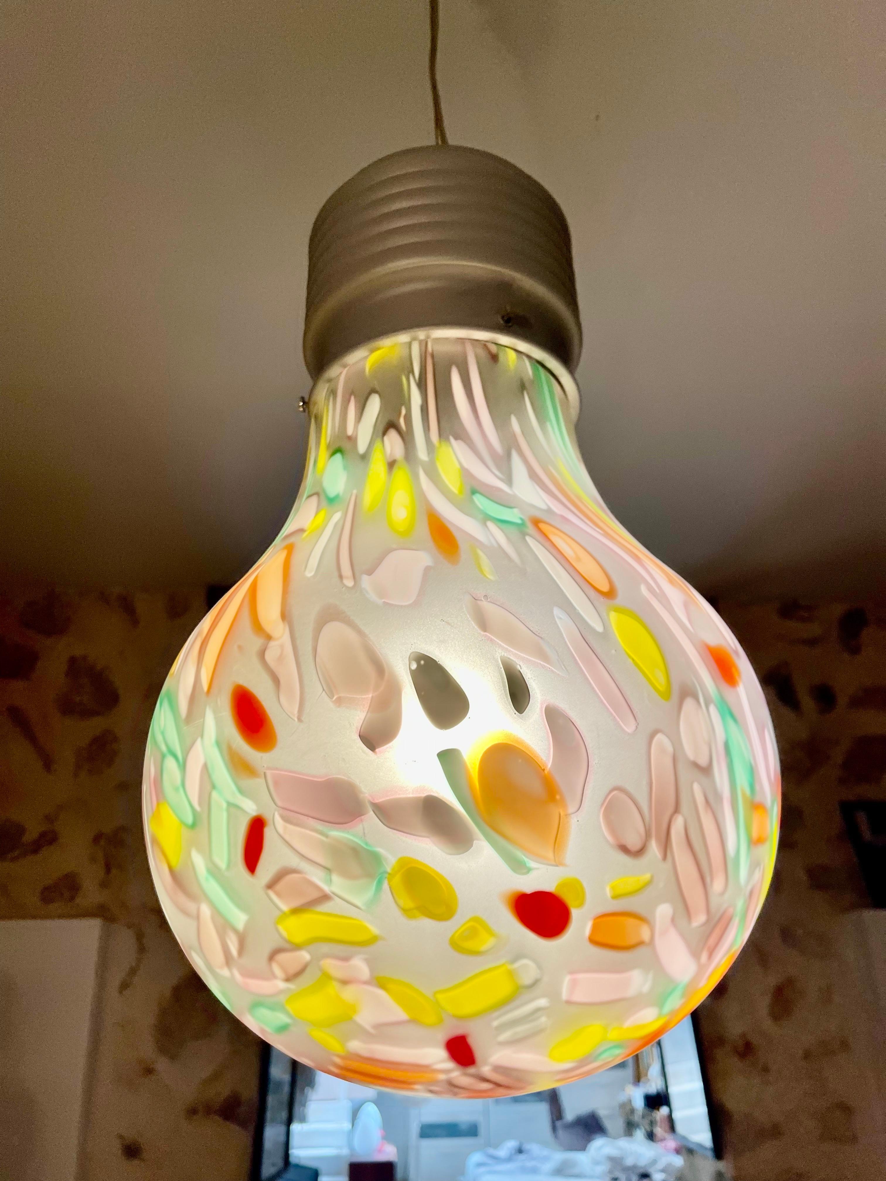 Una lampada dal design unico e originale della fine degli anni '80, progettata a forma di lampadina. Il vetro lucidato a mano ha una morbida finitura satinata che diffonde delicatamente la luce, creando un'atmosfera calda e accogliente. Sul decoro