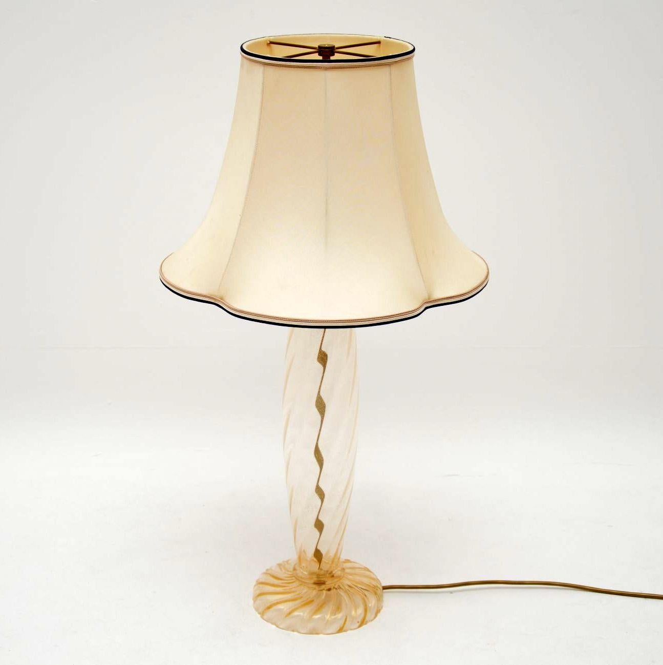 A beautiful hand blown Murano glass lamp, this was made in Italy by Donghia, it was designed by John Hutton. This dates from the late 20th century, it’s in great condition and is in good working order. The glass is clear and finished with gold dust,
