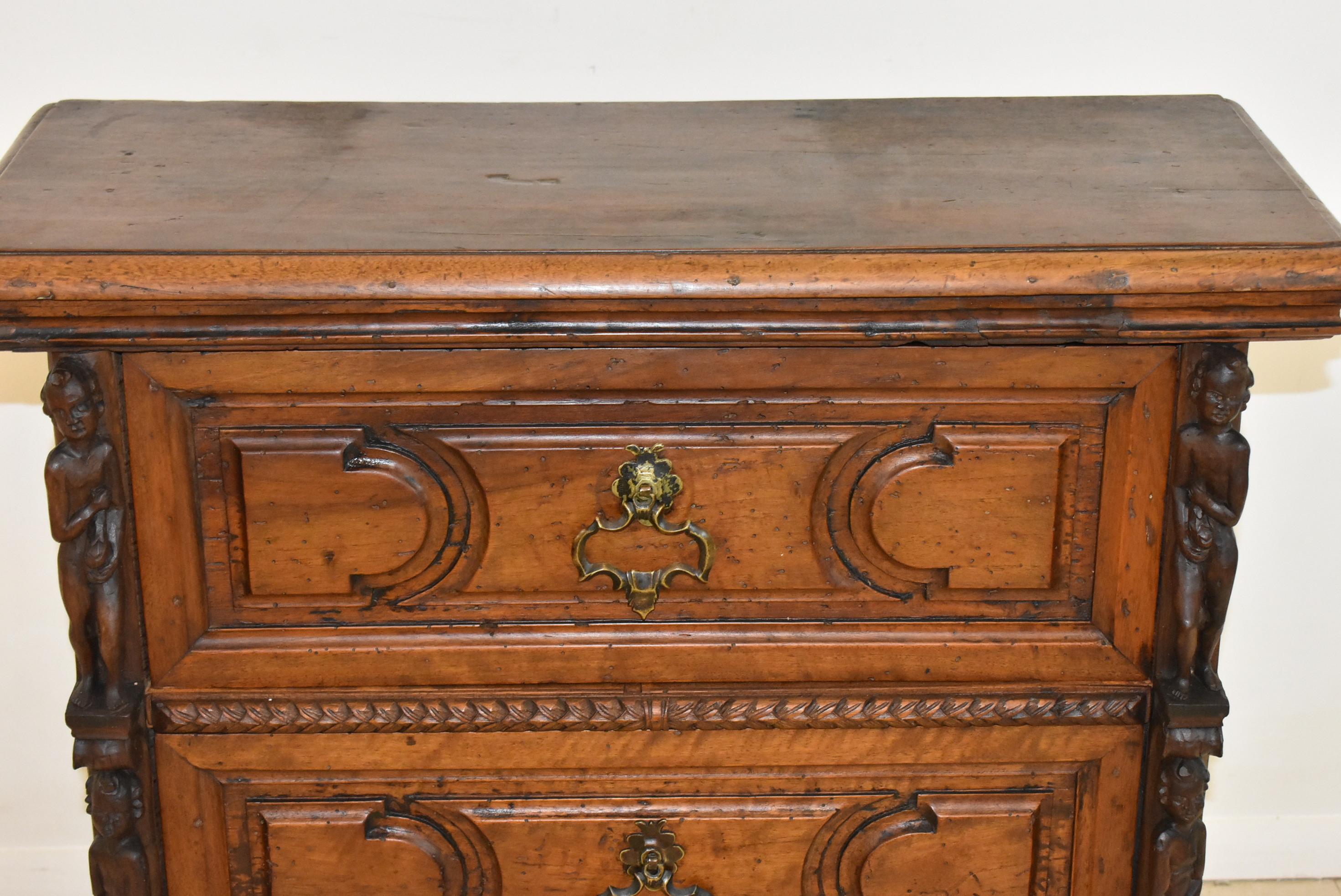 Splendida cassettiera italiana del XVIII secolo con tre cassetti, tre figure intagliate a mano su ogni lato e maniglie in ottone fatte a mano. Bellissimo artigianato del vecchio mondo. 