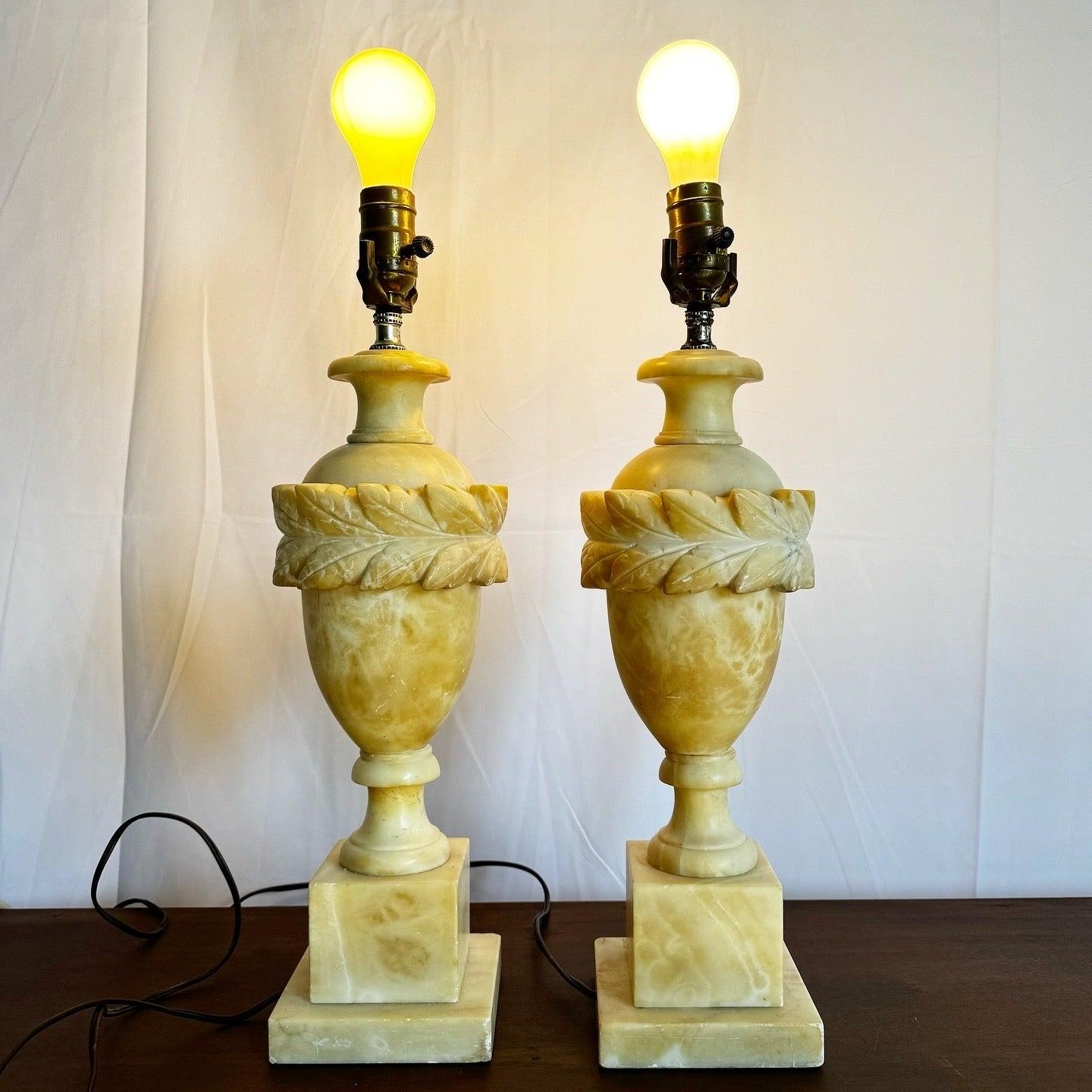 Paire de lampes de table italiennes en albâtre sculpté à la main, avec un design en forme d'urne et des détails de feuilles complexes, ajoutant une élégance intemporelle à n'importe quelle pièce.
 
 Nous vendons les articles tels qu'ils ont été