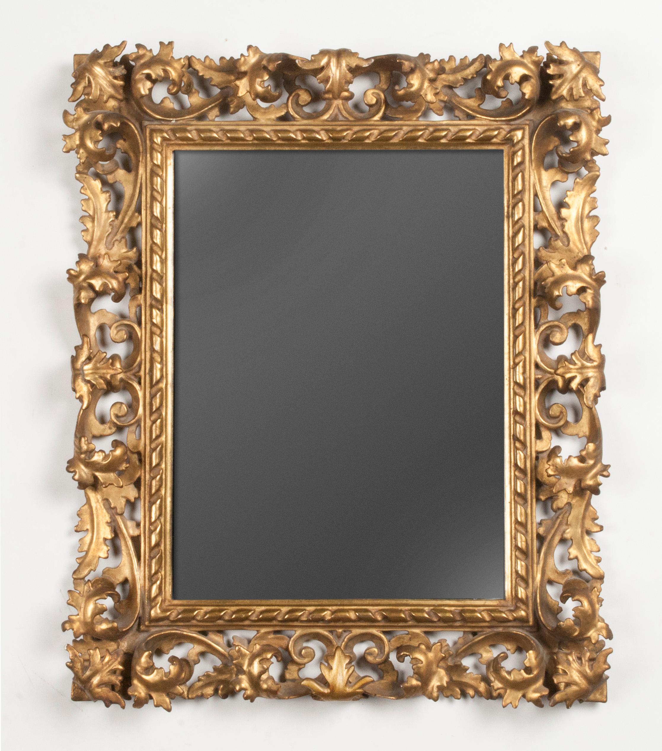 A late 19th century baroque revival wooden mirror from Italy. Refined hand carved from poplar wood. The frame is completely gold leaf gilt. The frame is deeply carved with scrolls and acanthus fronds. Mirror glass. For it's modest size, it is