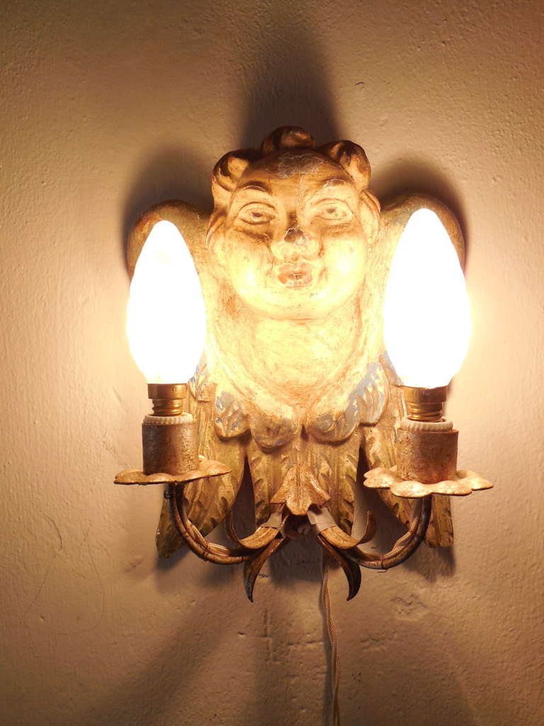 Heavy hand carved with original paint on wood. Housing two lights each. Will be rewired with certified US UL sockets for the USA and appropriate sockets for all other countries.  Silver gilt metal arms and bulb holders. Chipping as shown. Free