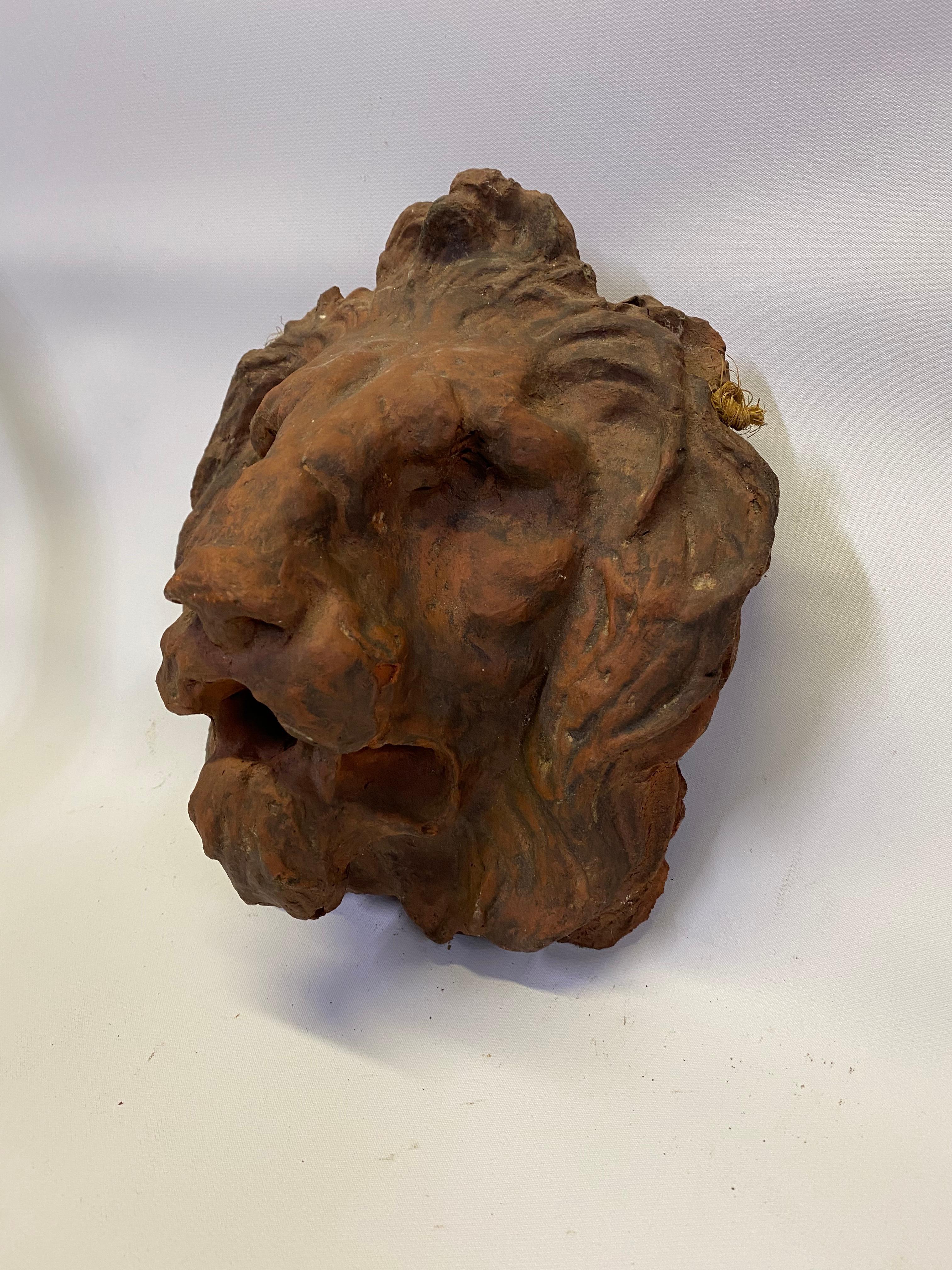 Hand carved and sculpted terracotta relief lion head. Finely detailed hanging wall hanging, Circa 1950-60. Structurally sound piece with no visible cracks, hairlines or restorations. Some rough edges. Old frayed string that can be replaced.