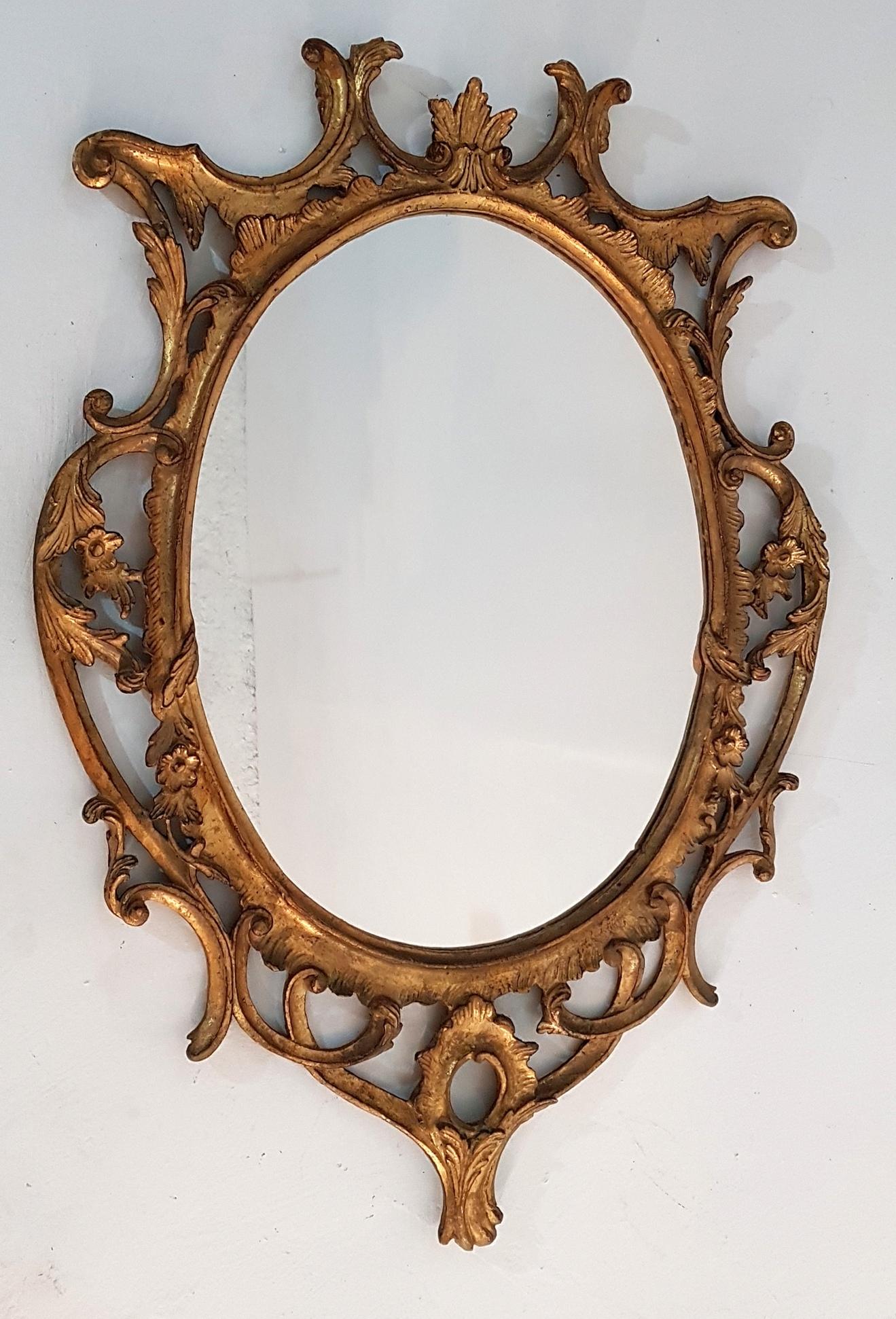 Ornately hand carved Italian Rococo mirror in gilded wood with exquisite form and outstanding craftsmanship.