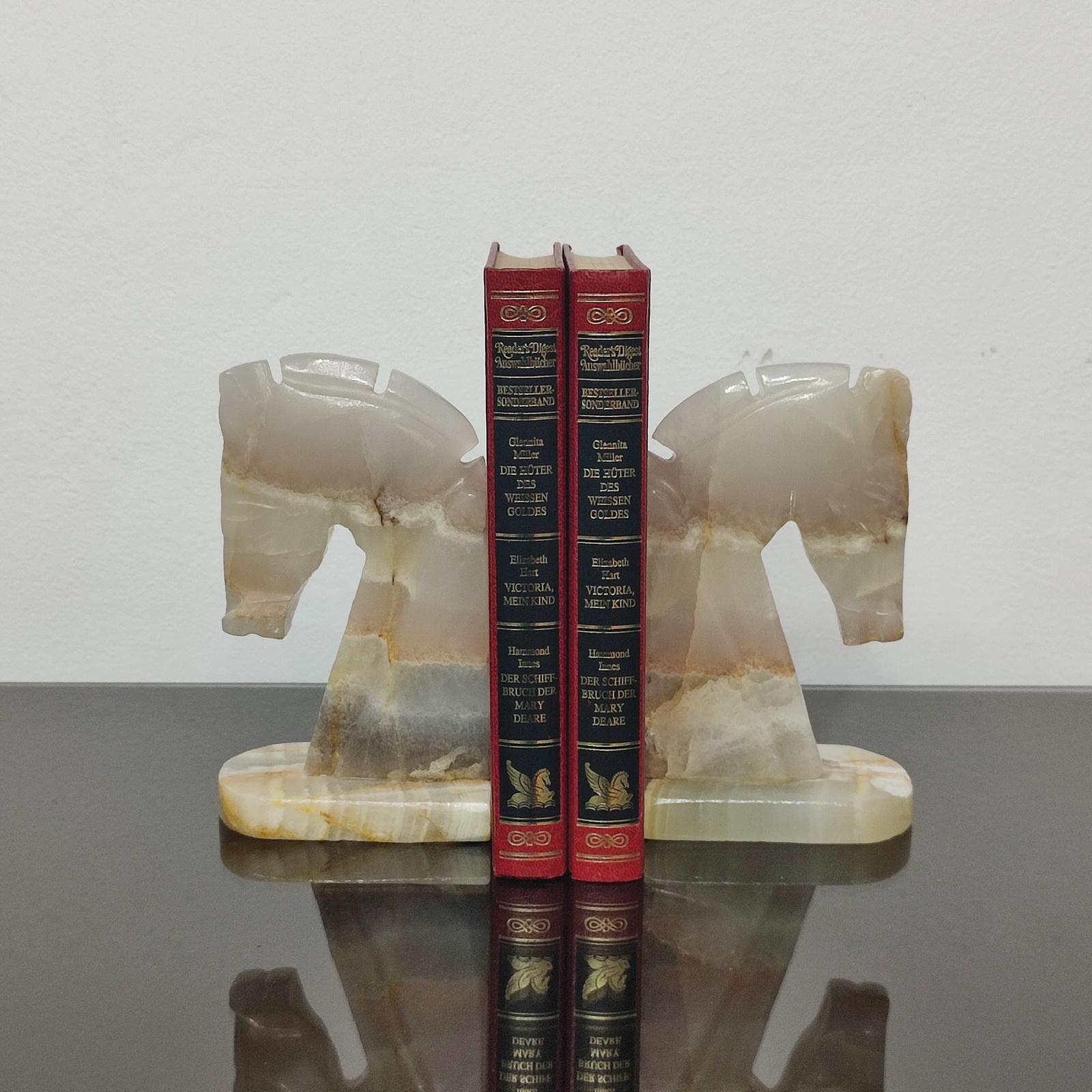Mid-century era pair of handcrafted art deco style horse sculpture onyx bookends.
Geometric design, Art Deco shaped reminding of the chess pieces, this pair of bookends are cut from the same piece of onyx, see the veins continuing form the left one