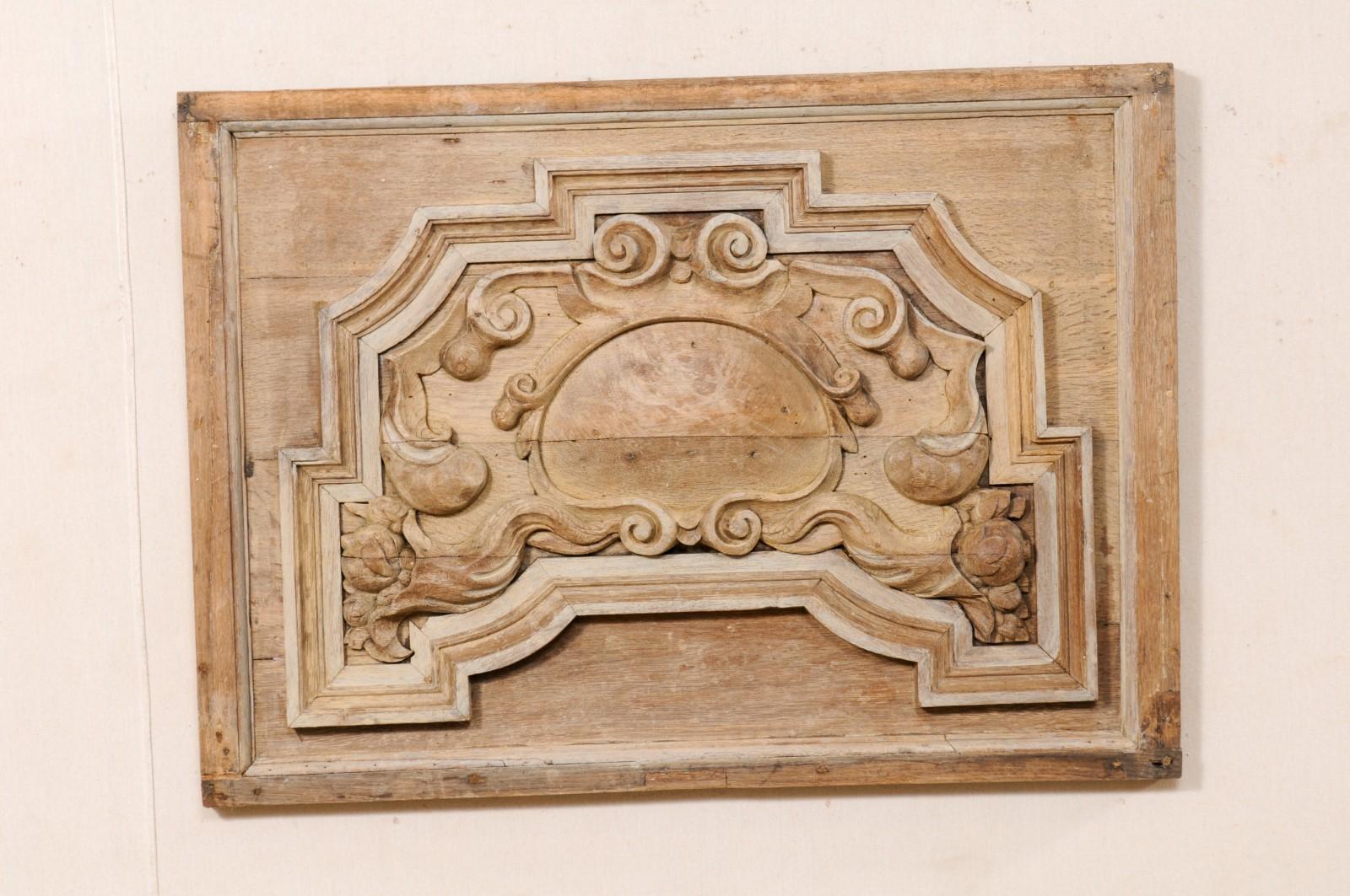 An Italian hand-carved wooden wall plaque from the 19th century. This antique wall decoration from Italy has a rectangular-shape, and features a motif of carved volutes, flowers, and central shell, framed within a simple molded surround. The