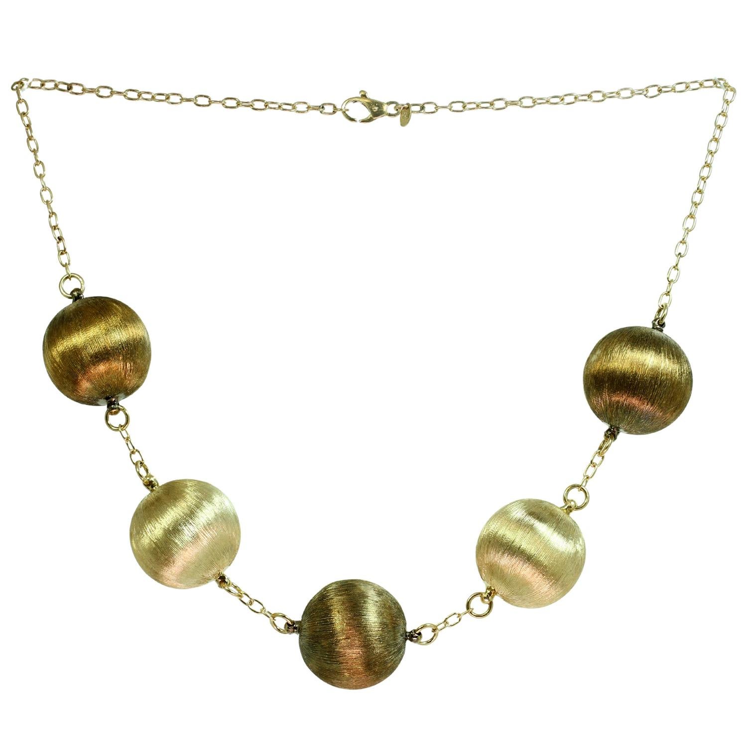 This gorgeous and chic Italian pair of necklaces features a collar chain complemented with round balls and a long chain complemented with oval elements, hand-crafted in 18k brushed rose green and yellow gold. Made in Italy circa 1990s. Measurements: