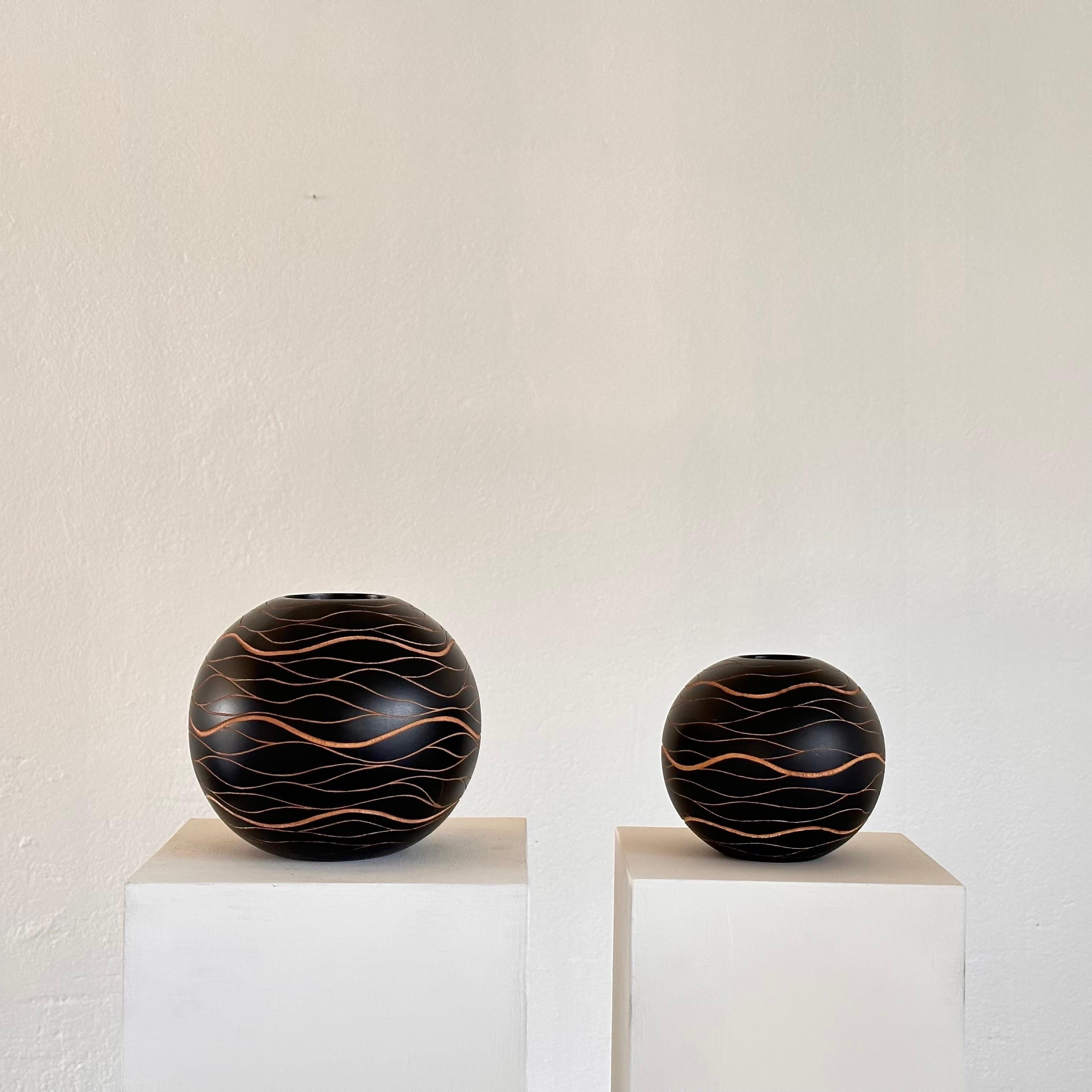 

Elevate your interior decor with this remarkable pair of hand-crafted wooden sphere vases, a testament to artisanal finesse and timeless elegance. Crafted in Italy during the vibrant era of the 1980s, these vases encapsulate an era of artistic