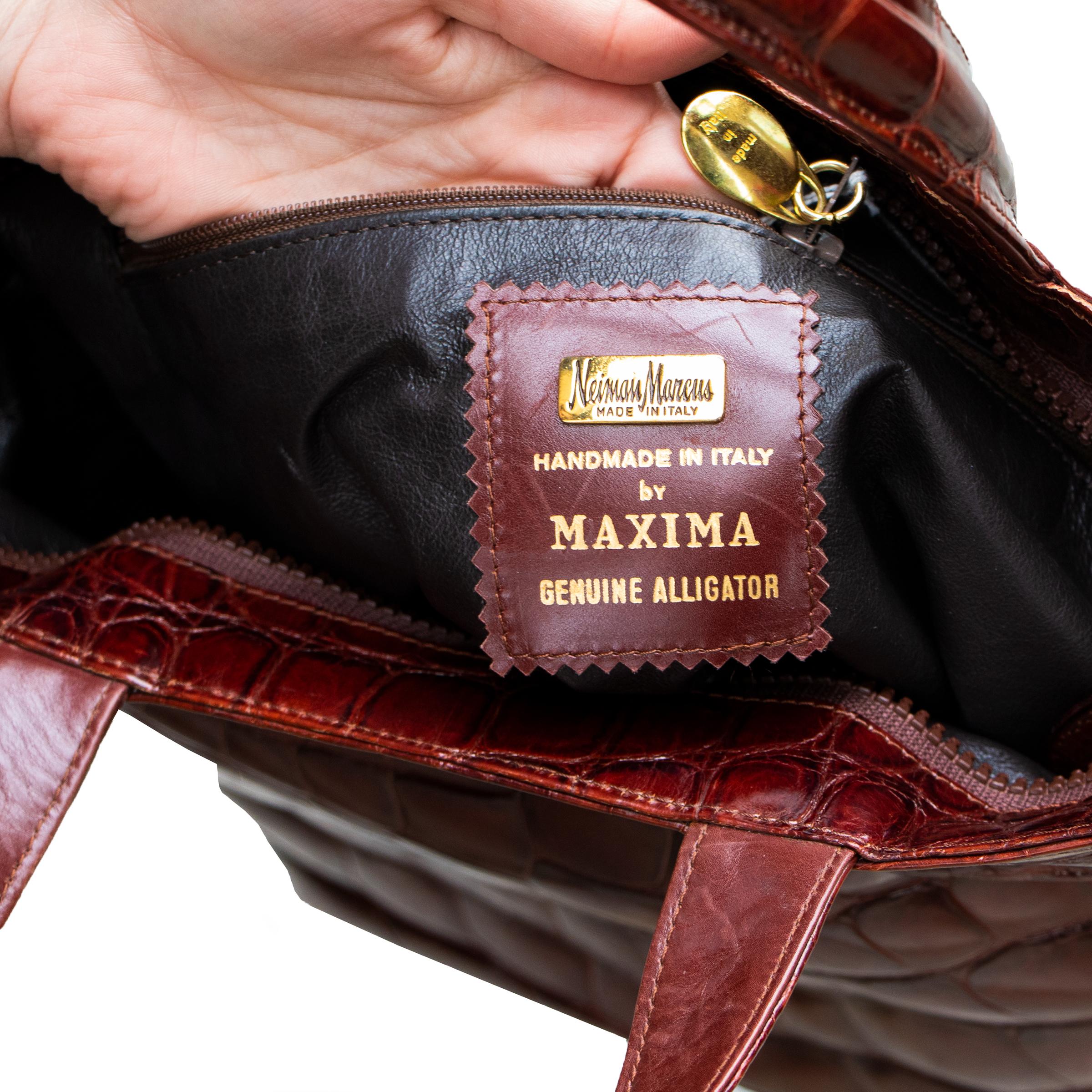 Fabriqué à la main à Milan, en Italie, ce sac à main en alligator véritable brun rougeâtre comporte une grande poche principale à fermeture éclair et une petite poche latérale supplémentaire à fermeture éclair. La fermeture de la poche principale