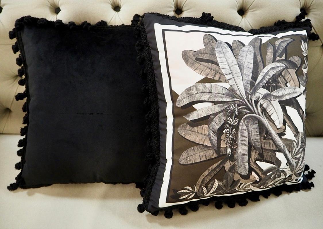 Un oreiller en velours et polyester avec des garnitures noires de la collection 