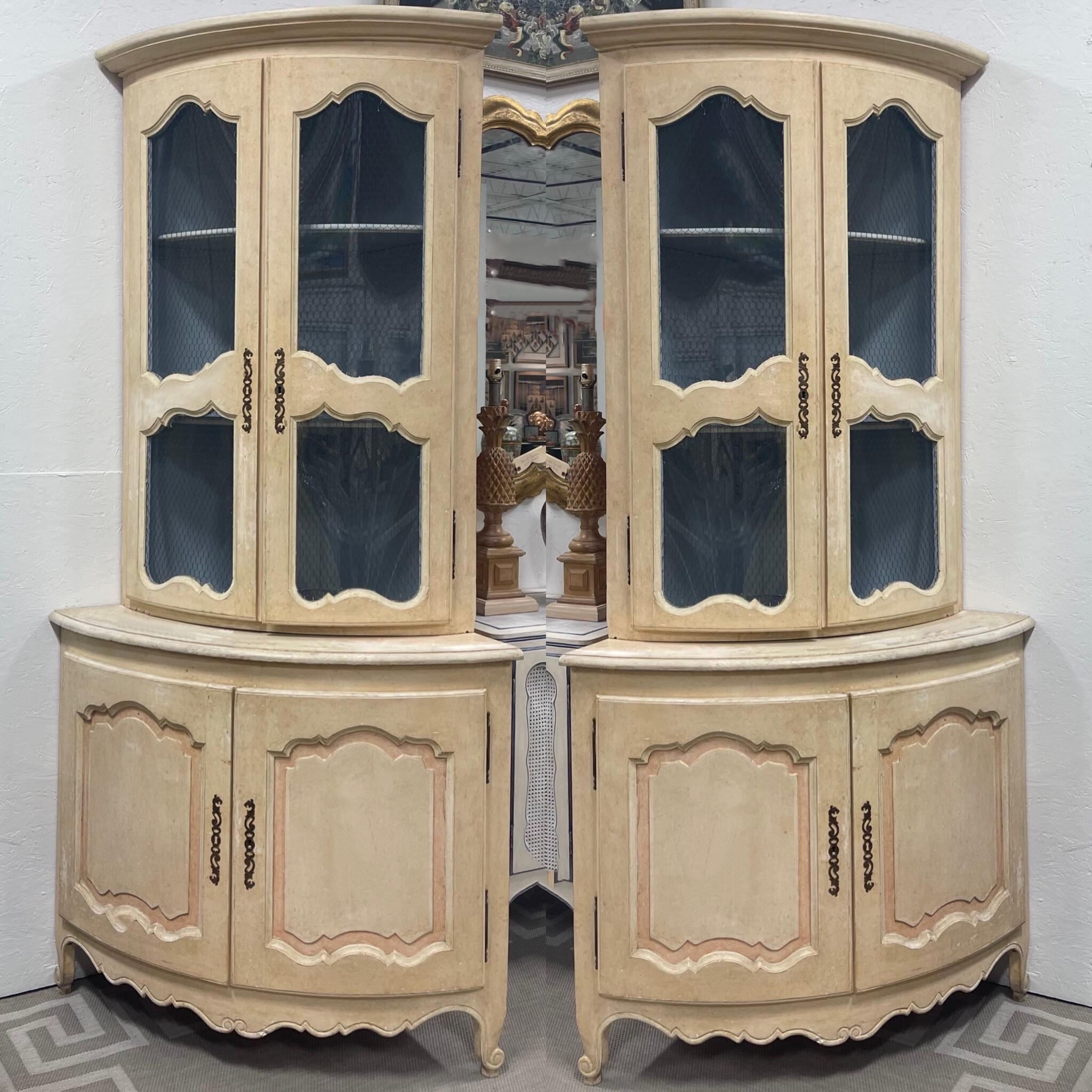 These are wonderful! This is a pair of hand painted Italian corner cabinets with French styling. The interior pops in a vibrant robin’s egg blue, and the exterior is ivory with a hint of salmon. The top has wire doors under a protective shield that