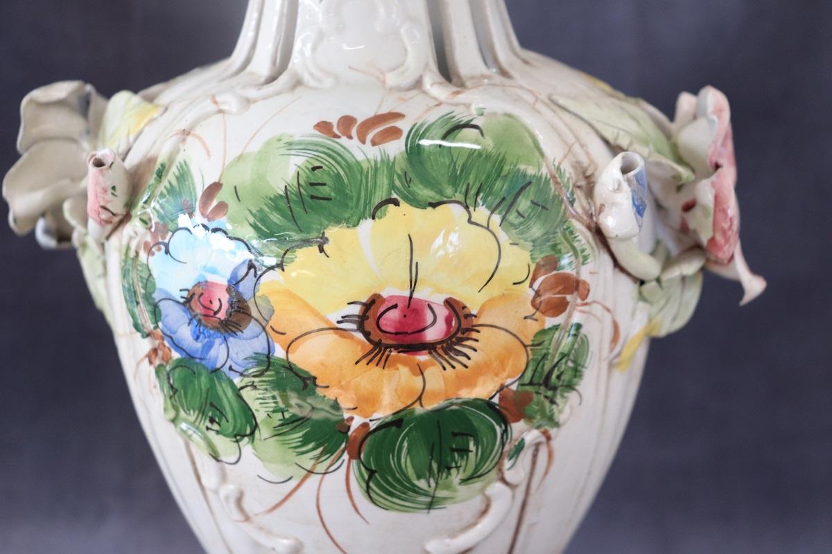 Italian hand painted ceramic vase, circa 1990s. Characterized by a classic line with floral decorations. Italian manufacturing brand based in Bassano, historical production of artistic ceramics. Two small and negligible breaks in the flower petals,