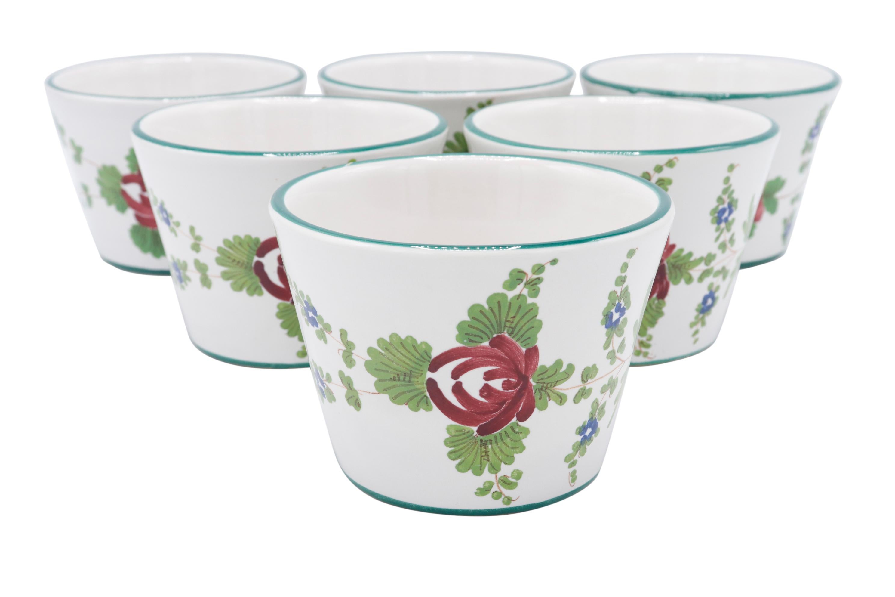A set of six Italian hand painted cups made by Ceramica Imola, founded in 1874. Decorated with a simple red and blue botanical pattern framed with blue and green lines on a white background. Marked underneath with their bee logo and C. Imola with