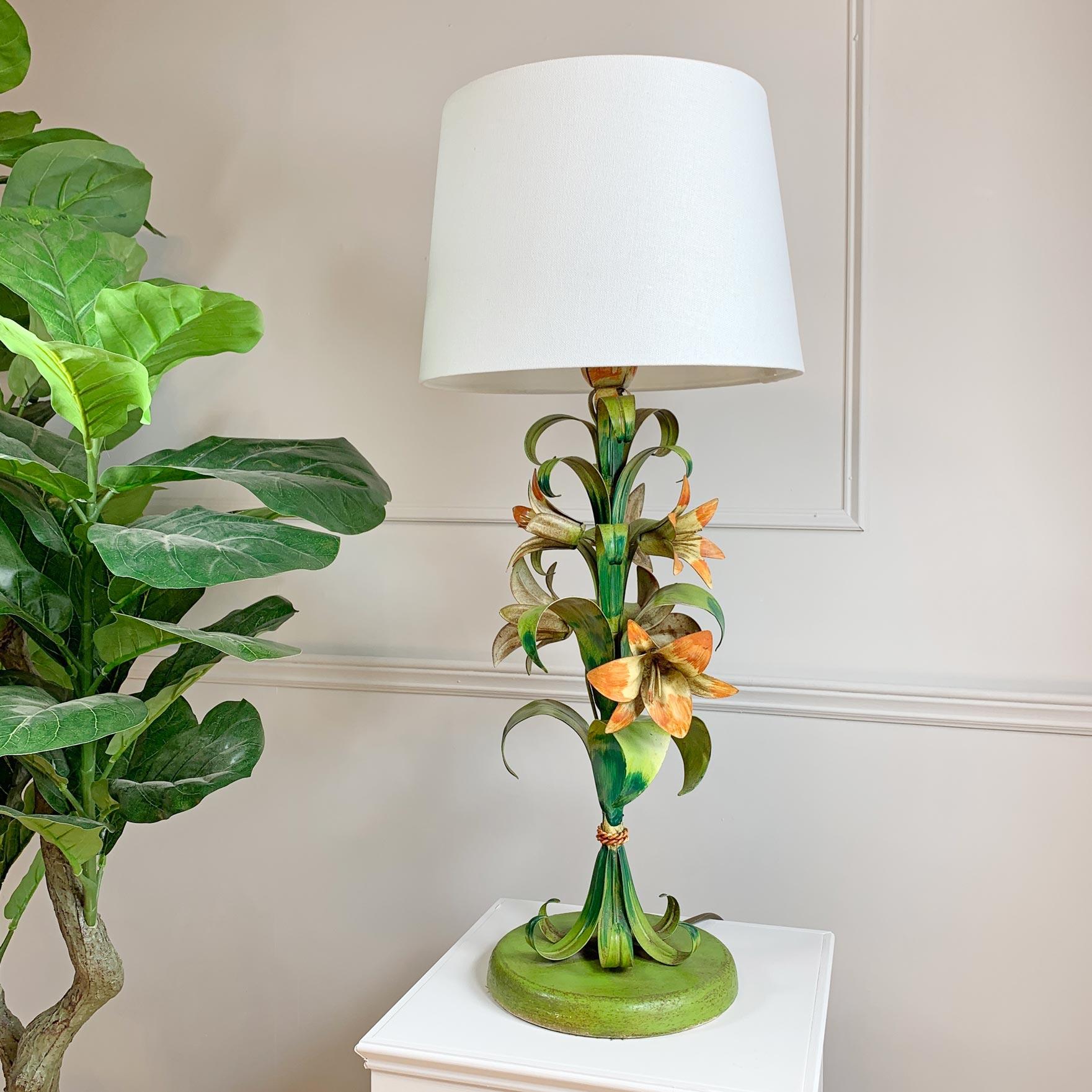 A very pretty 1950's Italian hand painted table lamp, decorate with Lilies and foliage, the lamp has a single B27 lamp holder and bears the original Made In Italy tag.

The lamp shade is a modern replacement.

Height with shade 70cm x Width