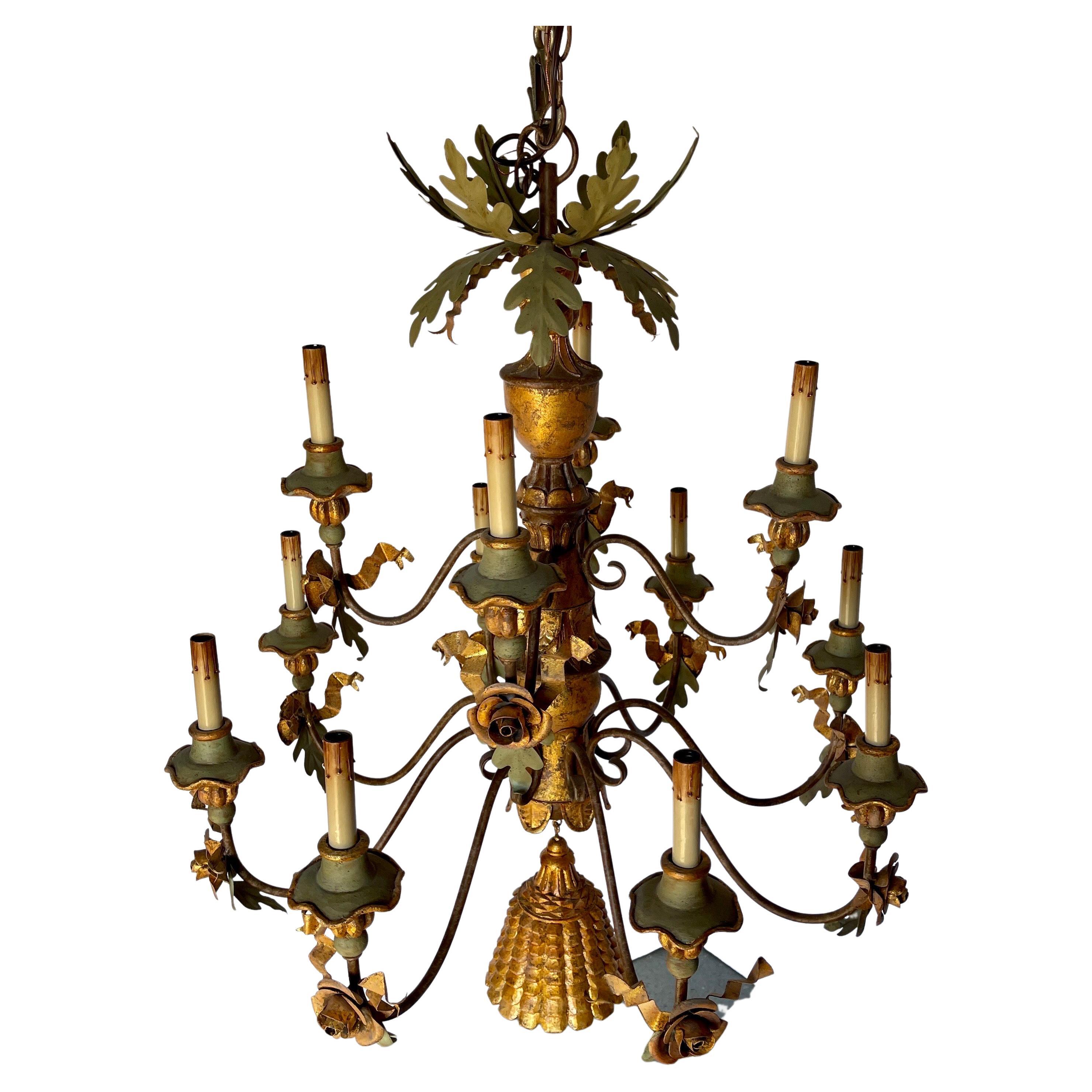 Lustre en fer vert et bois doré avec détails de fleurs et grande pampille dorée

Exceptionnel lustre de 12 lampes à décor de feuillage doré, de tole, de feuilles de chêne vertes et de fleurs en métal. Une grande houppe sculptée vient compléter le
