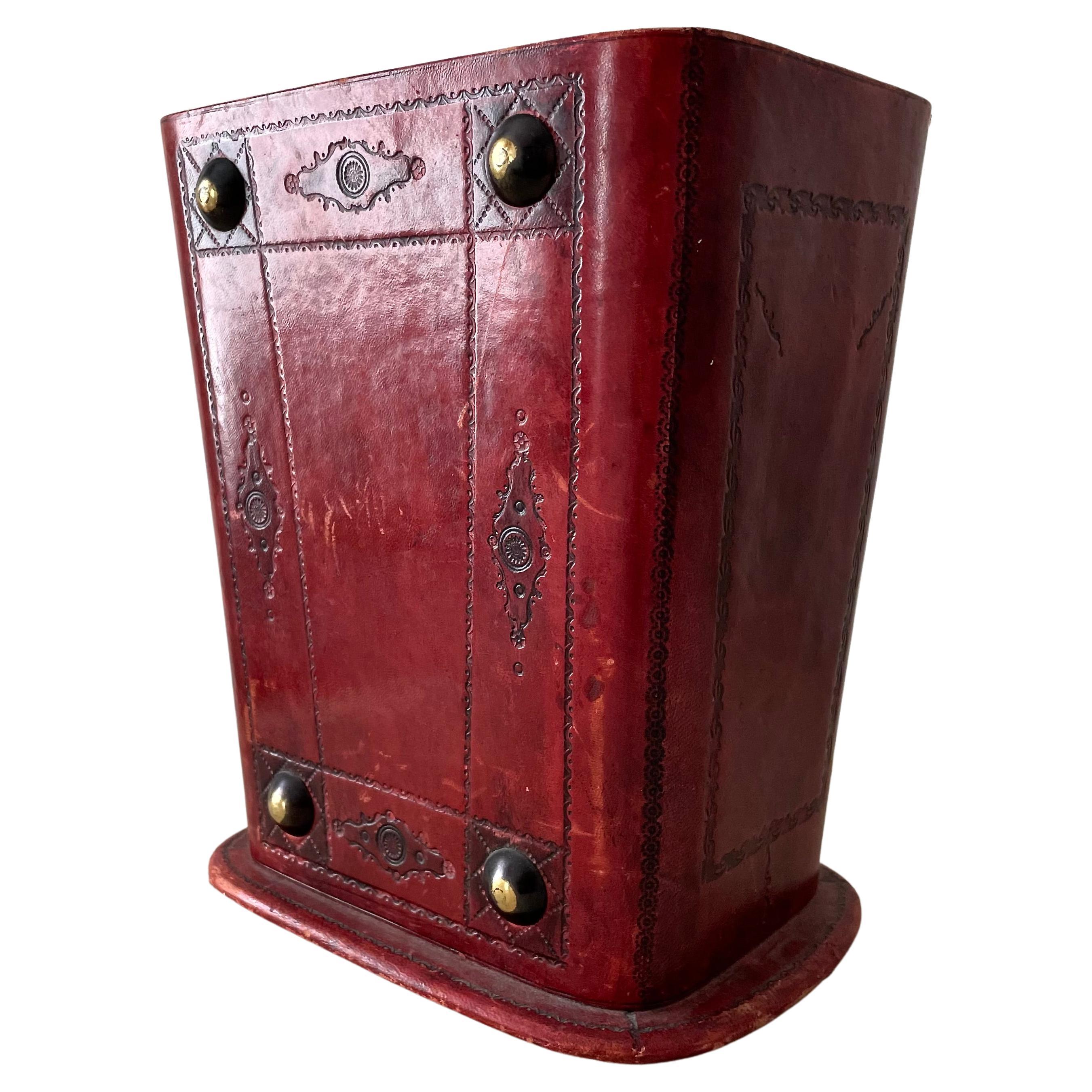 Red leather waster basket or trash can - for wastepaper or creative use. Lined in a brown velvet on inside and base. Features patinated brass decorative domes in each corner. Adds character to any office. 

 Lined on the inside and bottom with