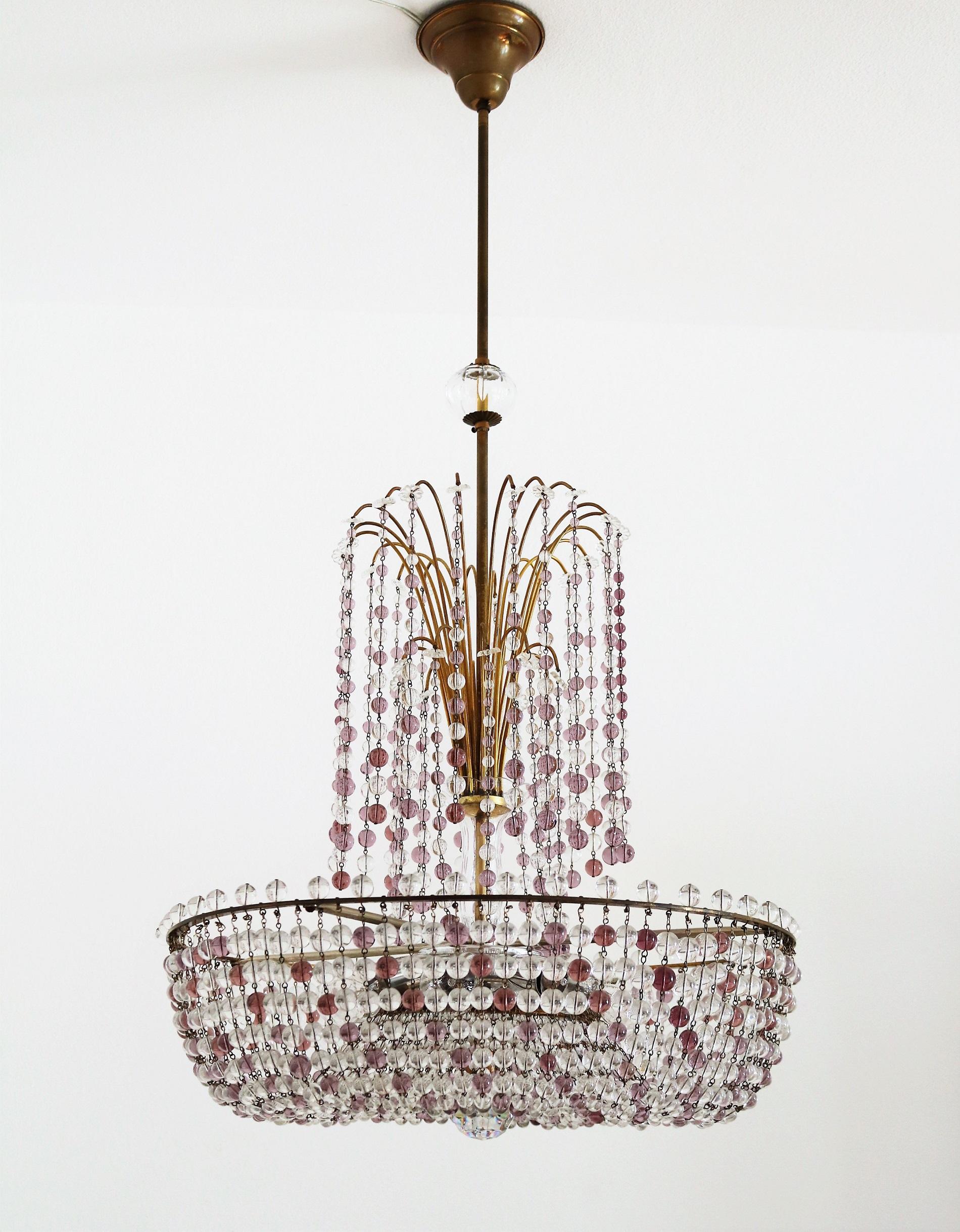 Gorgeous and rare big chandelier with countless Murano crystal drops in transparent and light purple (lavender - lilac) color.
The lamps frame as well as bar to ceiling and ceiling rose are made of brass with nice dark patina.
Inside the lamp are