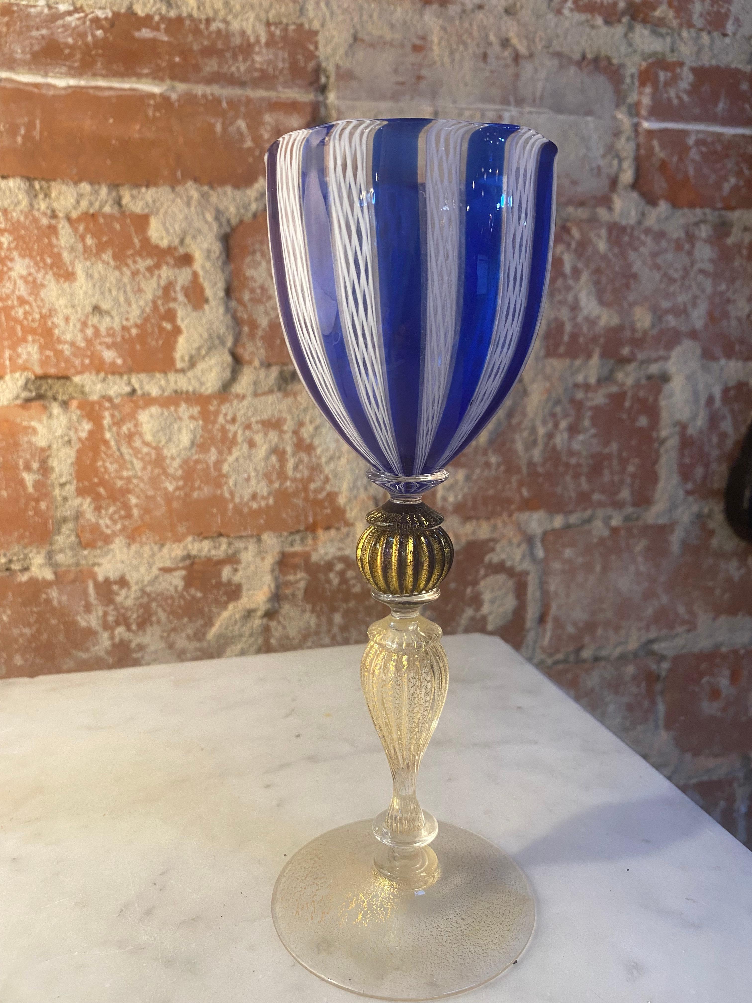 Italian handcrafted chalice in blown Murano glass clear color and blue, 1980s
This elegant chalice is rich in lovely details that add harmoniously to its grace. The stem is richly adorned with different decorations.