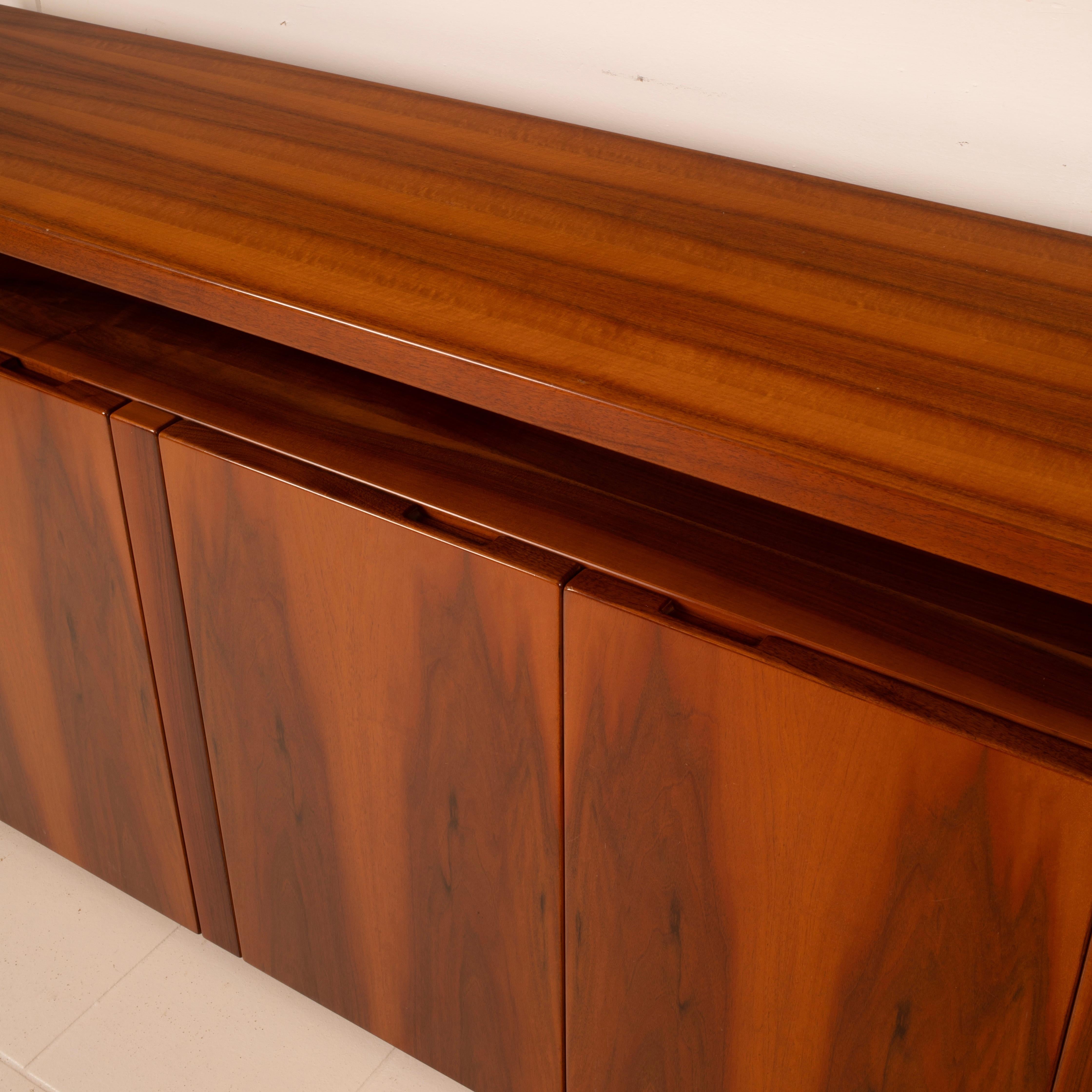 Stunning four-door sideboard made in Italy during the 1970s, likely custom-designed and entirely handcrafted as a unique piece.
Structure in solid walnut wood, with a pierced black-stained ash detail.

The piece stands out for its rigorous
