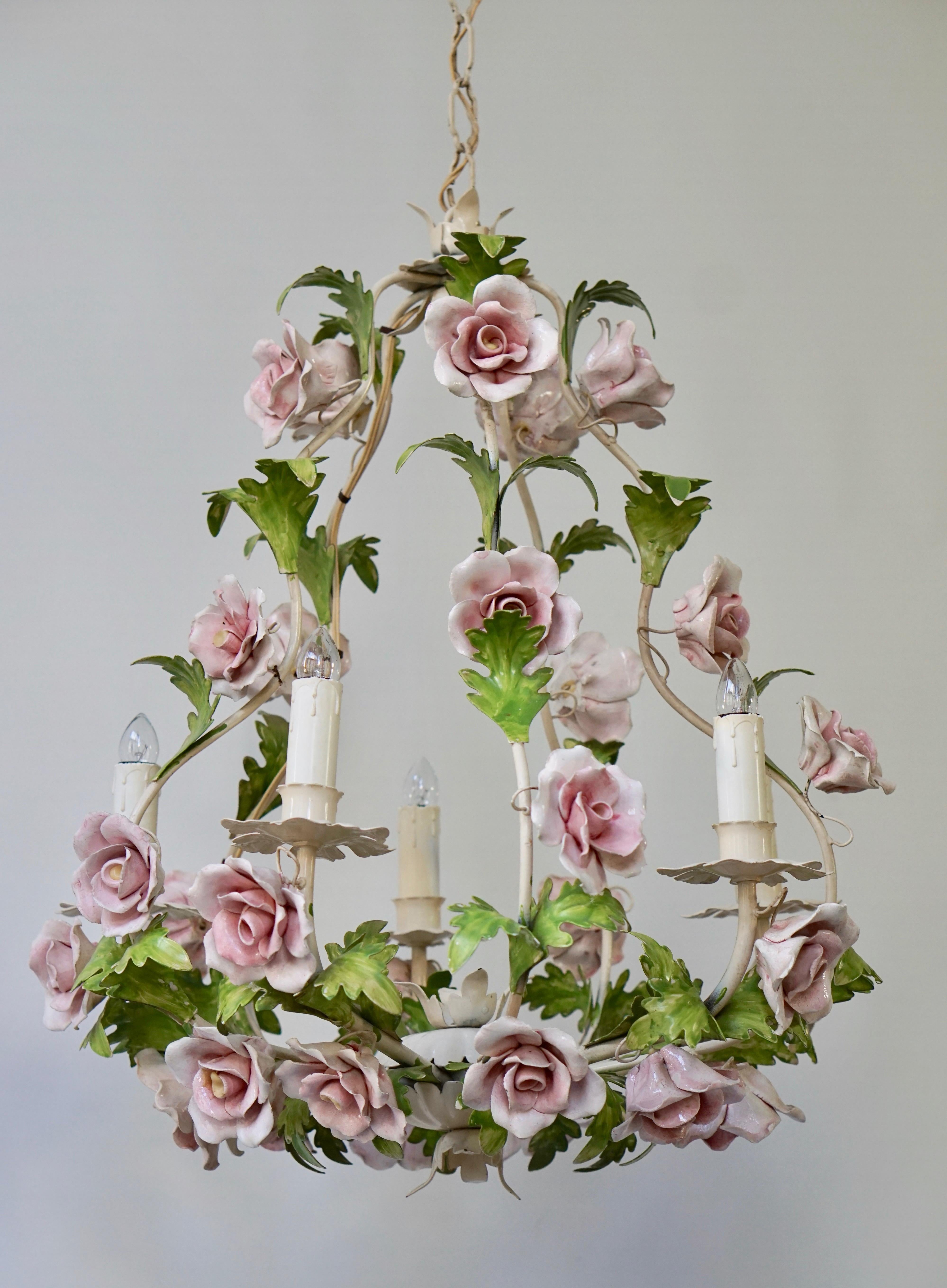 An Italian handcut tole chandelier. The cage form metal frame ornamented with tole leaves, and pink-white porcelain flowers.
Measures: Diameter 50 cm.
Height fixture 58 cm.
Total height 110 cm.
Five E14 bulbs.