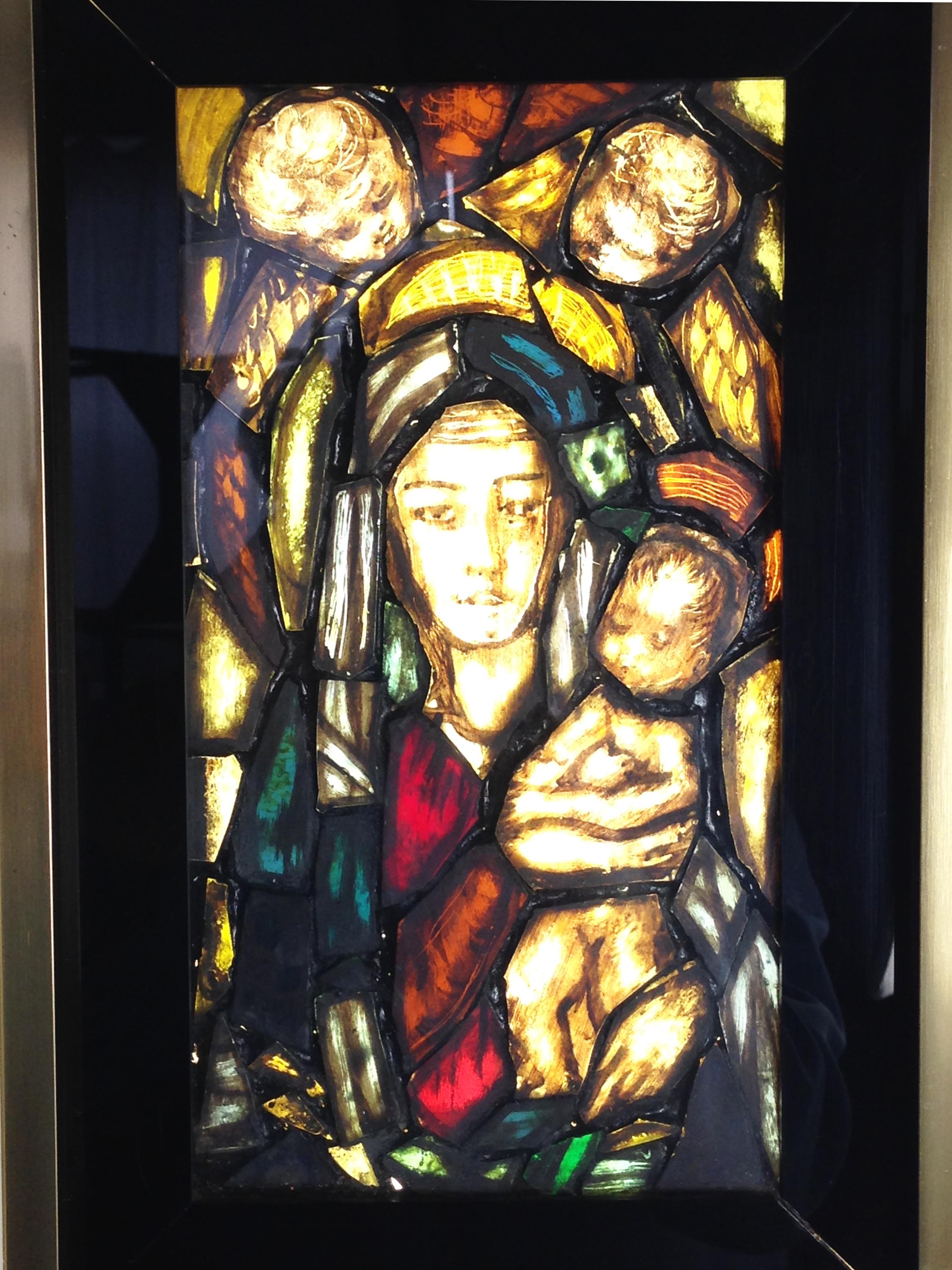 This artistic window was handmade in Italy in the 1960s. It's made from a ivory painted metal box, with plexiglass and golden aluminum passepartout. The religious representation is a patch work of glass fragments painted from the back. Inside the