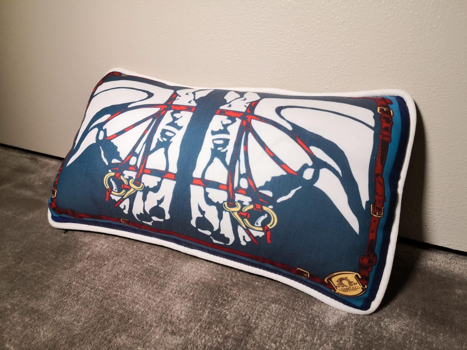 A polyester and velvet (on the back) pillow pillow showing a contemporary horse heads with horesebit an belts.The main colors are blu and red. It's available in other colors, which you can see in our main board.
This pillow comes out as a set of
