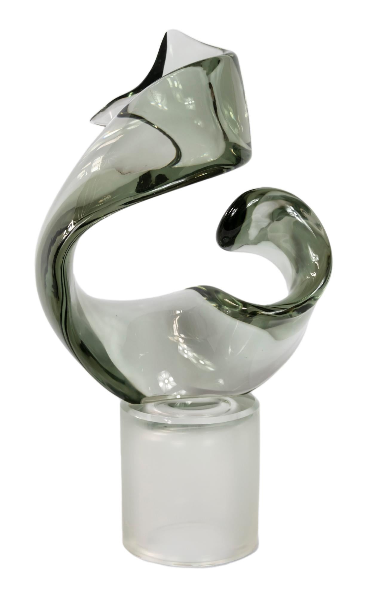 Italian handmade Murano glass abstract design sculpture.
Created and signed by L. de Roi.
The base is round in frosted color glass. There is a small outlet on the base for the lighting function.
The sculpture element is in clear light grey