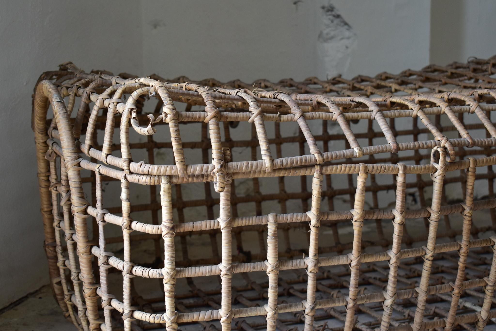 Un sorprendente cesto vintage italiano degli anni '70, meticolosamente intrecciato a mano in bambù. Il suo design scultoreo a griglia aperta mette in risalto l'artigianalità e l'eleganza utilitaristica degli oggetti rurali italiani. Originariamente