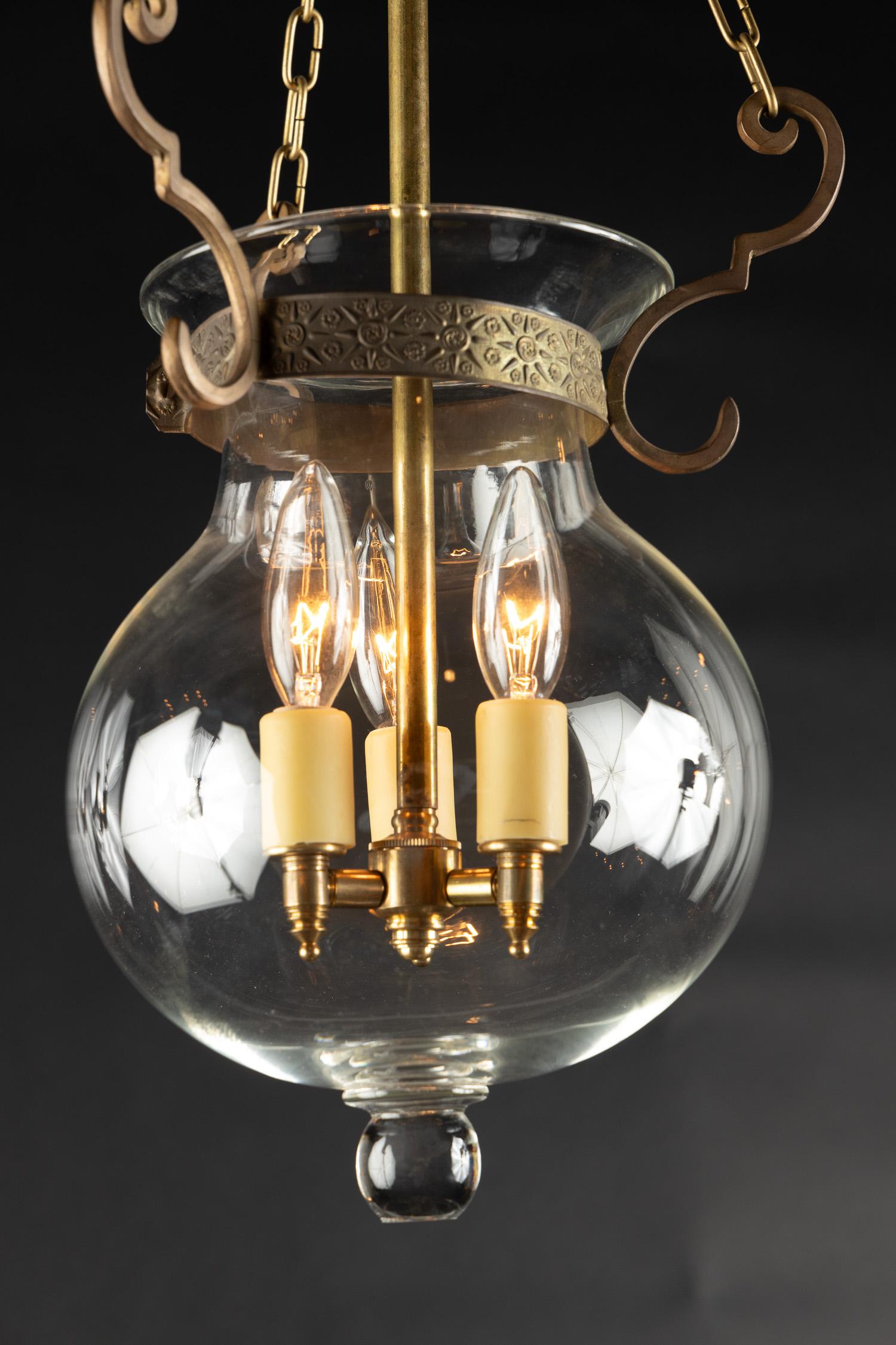 This simple yet beautiful small Italian cloche lantern features hand blown glass in a classic baluster shape. The mid 20th century piece features bronze scroll work at the top which connects to the glass lip, accompanied by a bronze center stem