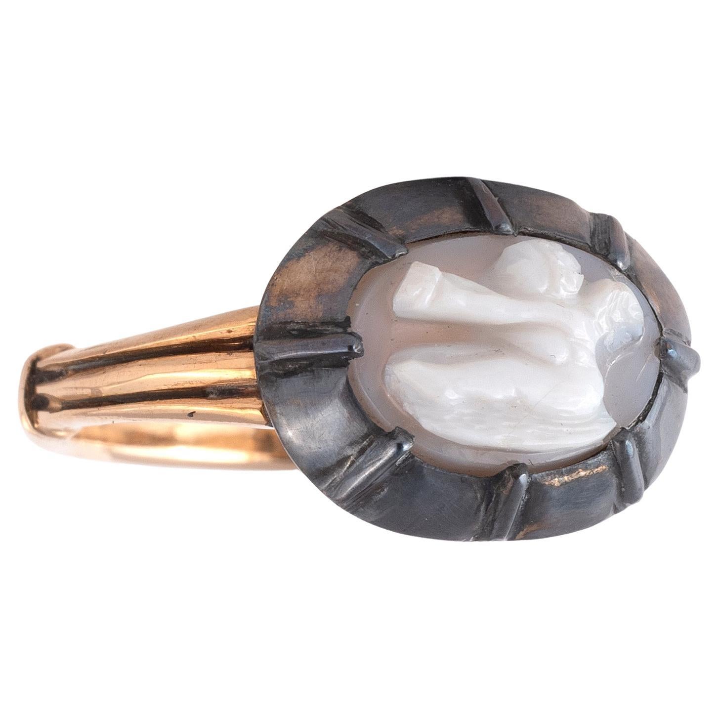 A hardstone cameo depicting a cupid in silver and gold collet settings.
The size cameo is 0.7 x 1.1 cm 
Size 7
Weight: 5.59 g



