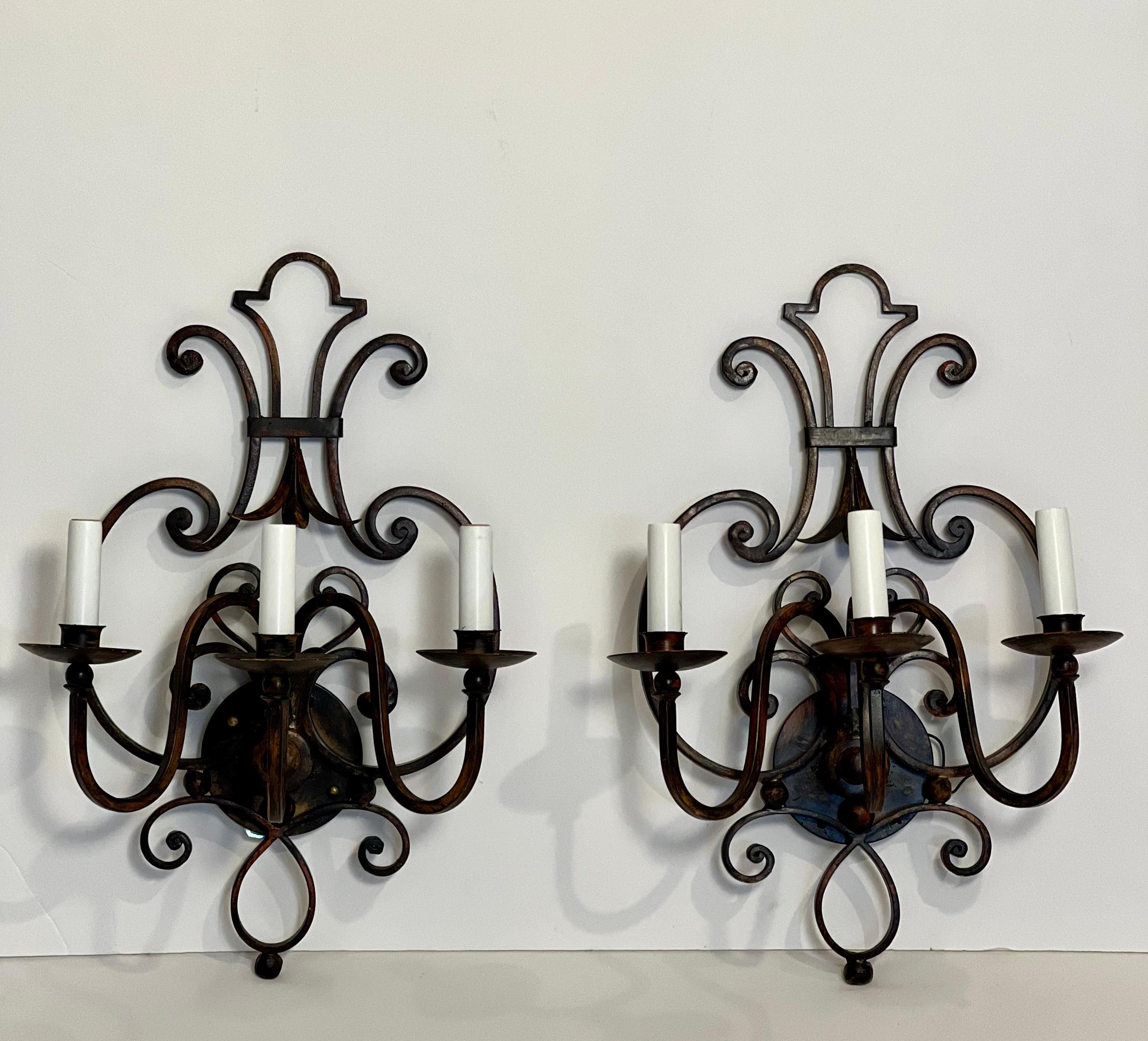 Pair of gorgeous Italian hand wrought iron sconces with a blackened rust finish.

Crafted in early 2000s but have never been used as they were floor samples in an upscale lighting boutique. Shades are included should you prefer to use them. They
