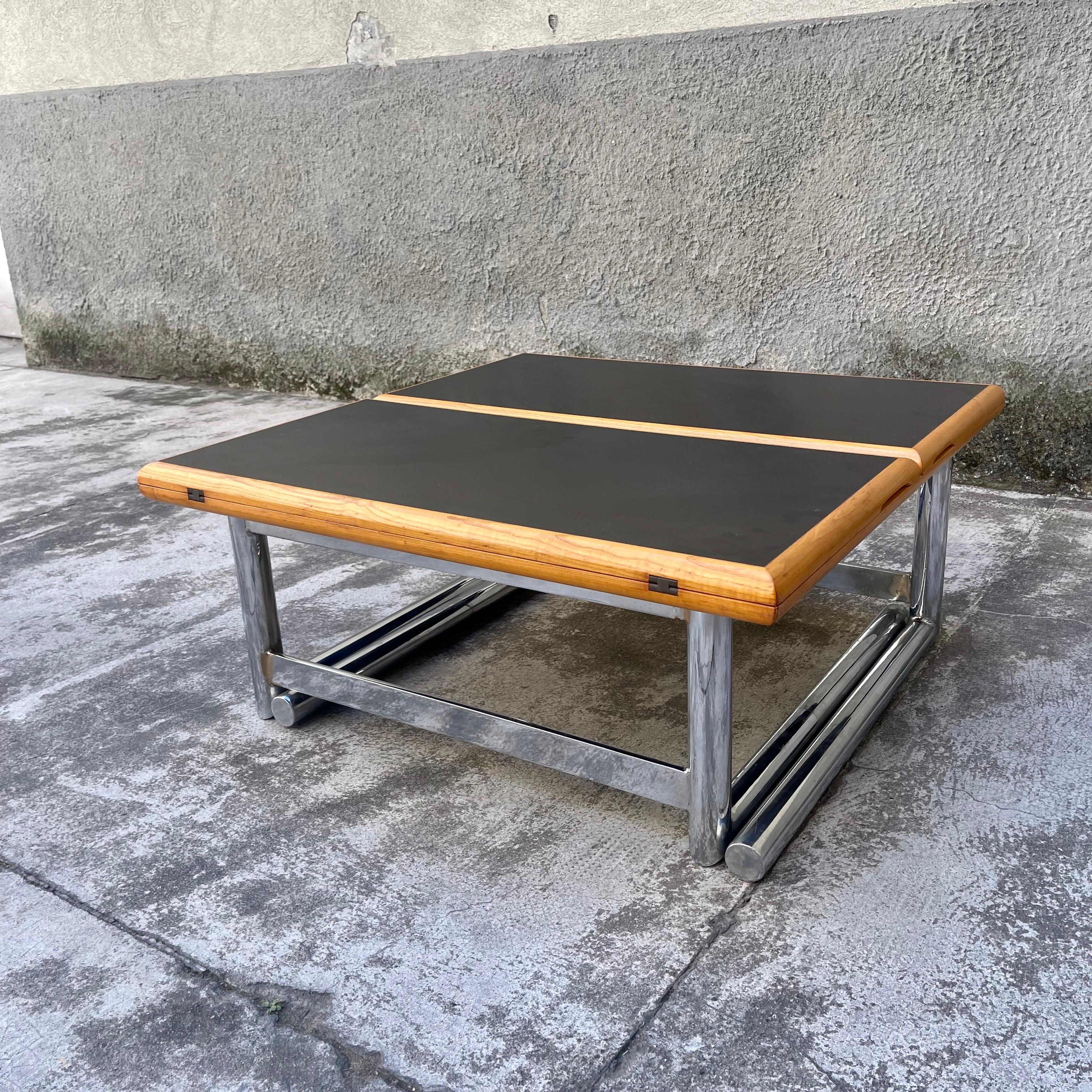 This very special square coffee table, fitted with solid steel legs, can be transformed into a large dining table by simply lifting it up so that the legs, opening, raise the top bringing it to the height of a dining table. At this point it will be