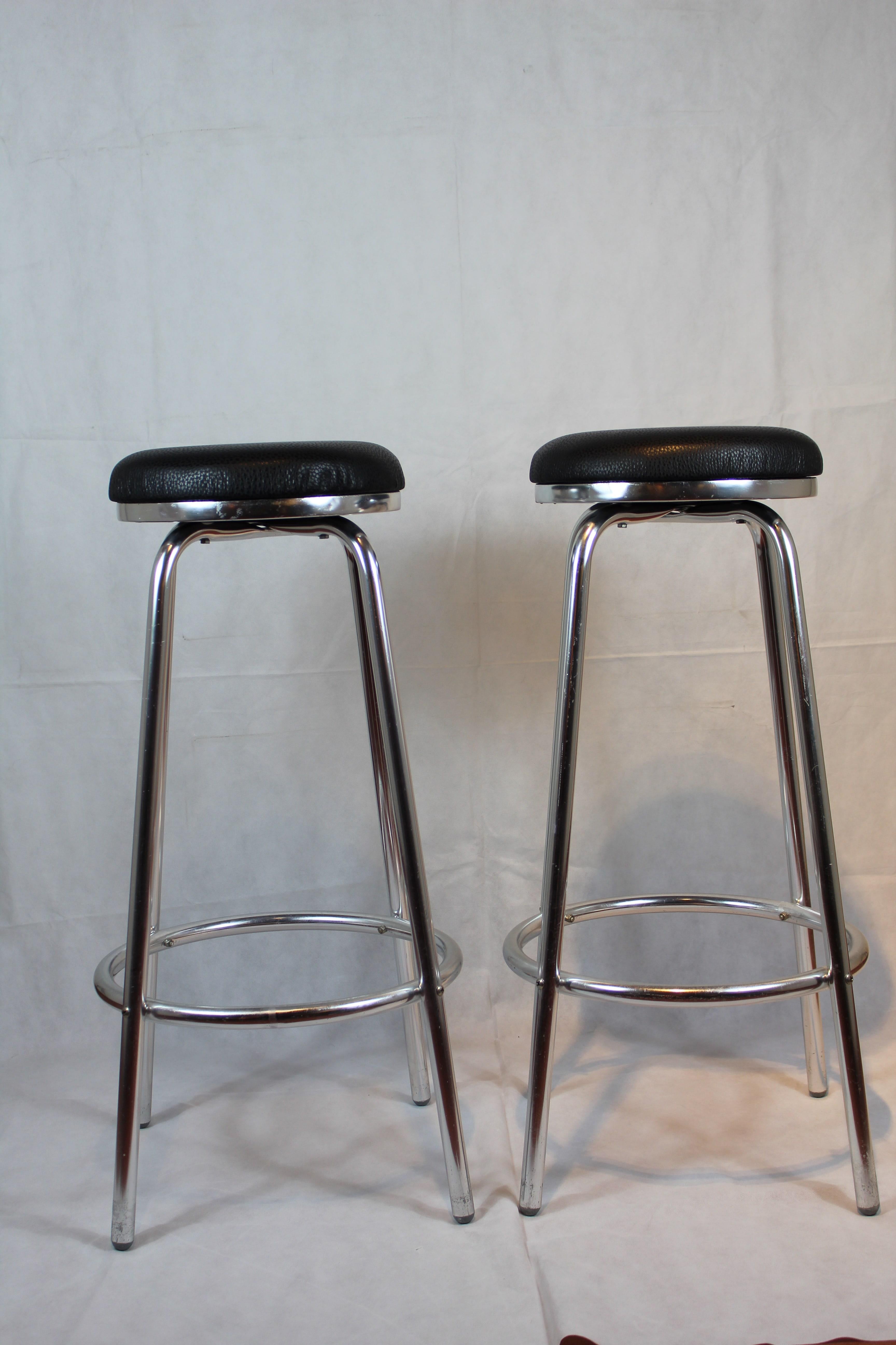 Italian high stools, aluminium legs, black leather seats.
