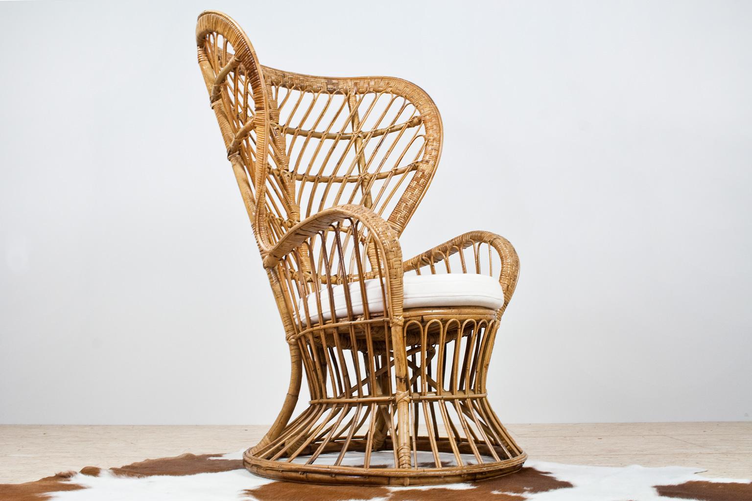 A true Italian Bohemian eyecatcher is this high wingback armchair. This handcrafted rattan piece was designed by Lio Carminati in the 1950s. This item was specifically designed for the prestigious cruise ship 'Conte Biancamano.' The listed, almost,