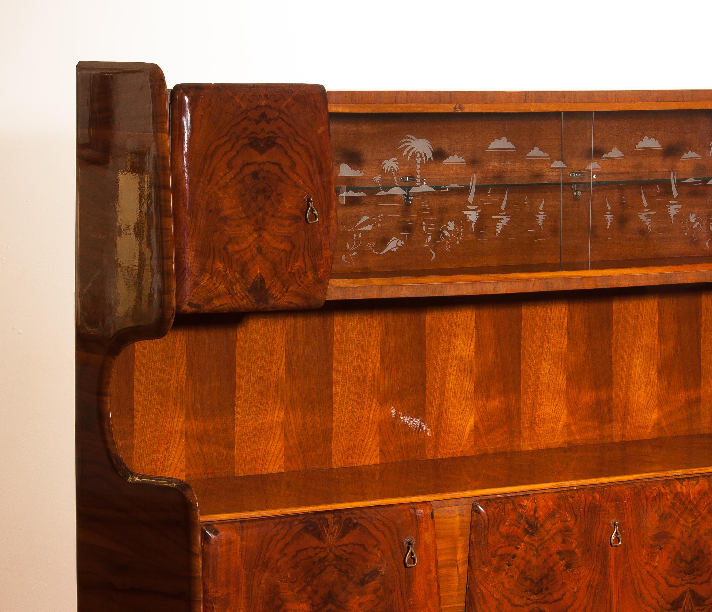 This exceptional beautiful highboard or buffet cabinet made of burl wood and walnut veneer is from 1950s and designed by Vittorio Dassi.
 Made in Milan, Italy. It has five cabinets two glass sliding doors with the typical summer design and behind