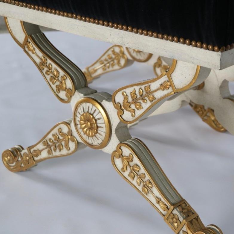 Italian Hollywood Regency benches in carved wood with newly upholstered black velvet. Each bench features painted gold accents and is in excellent vintage condition having wear consistent with age and use.