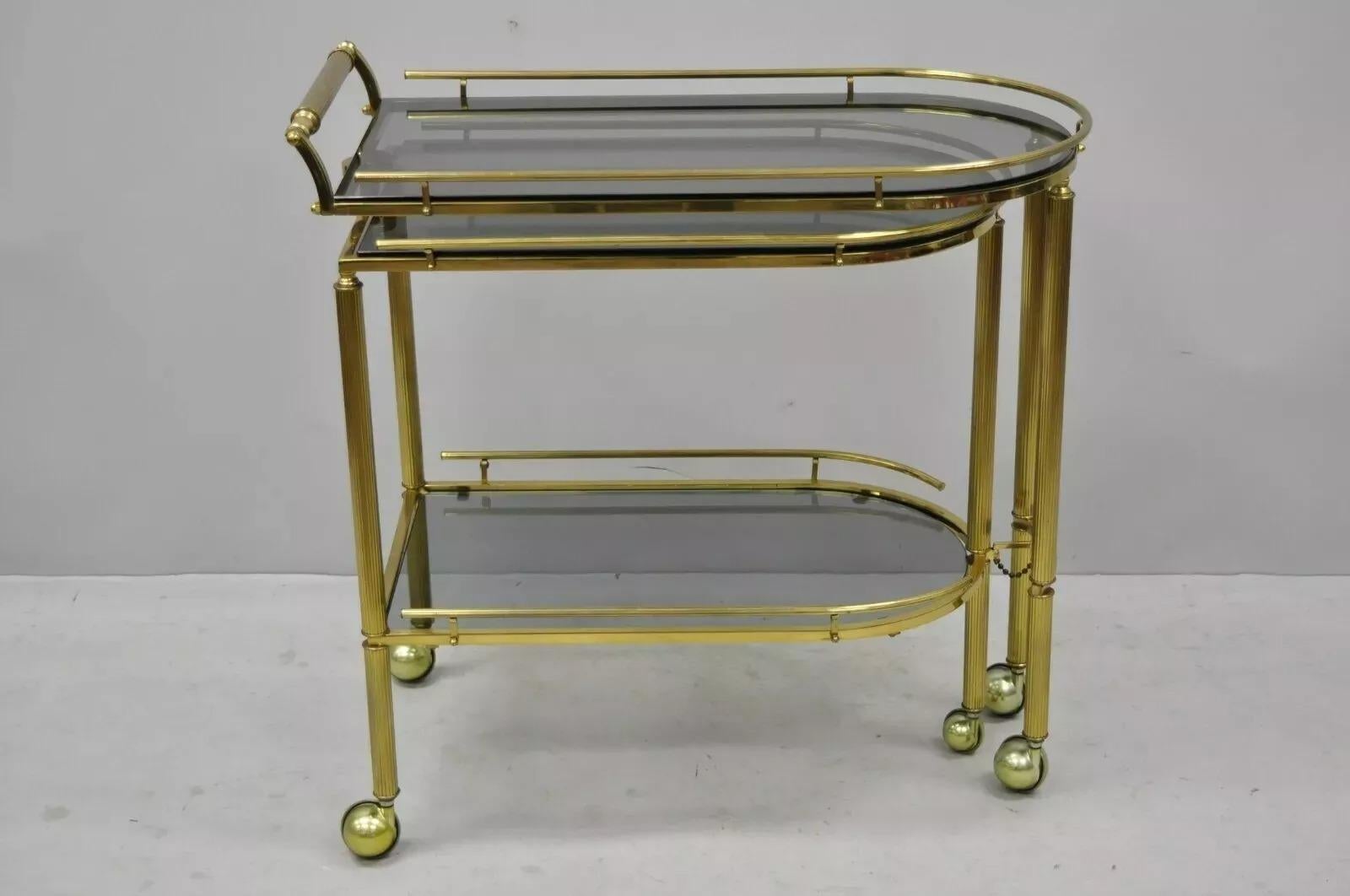 Vintage Brass Italian Hollywood Regency Swivel Rolling Bar Cart Server w/ Smoked Glass. Item features a unique swing/swivel frame which opens to server size, rolling casters, 2 smoked glass surfaces, brass construction, quality craftsmanship, great