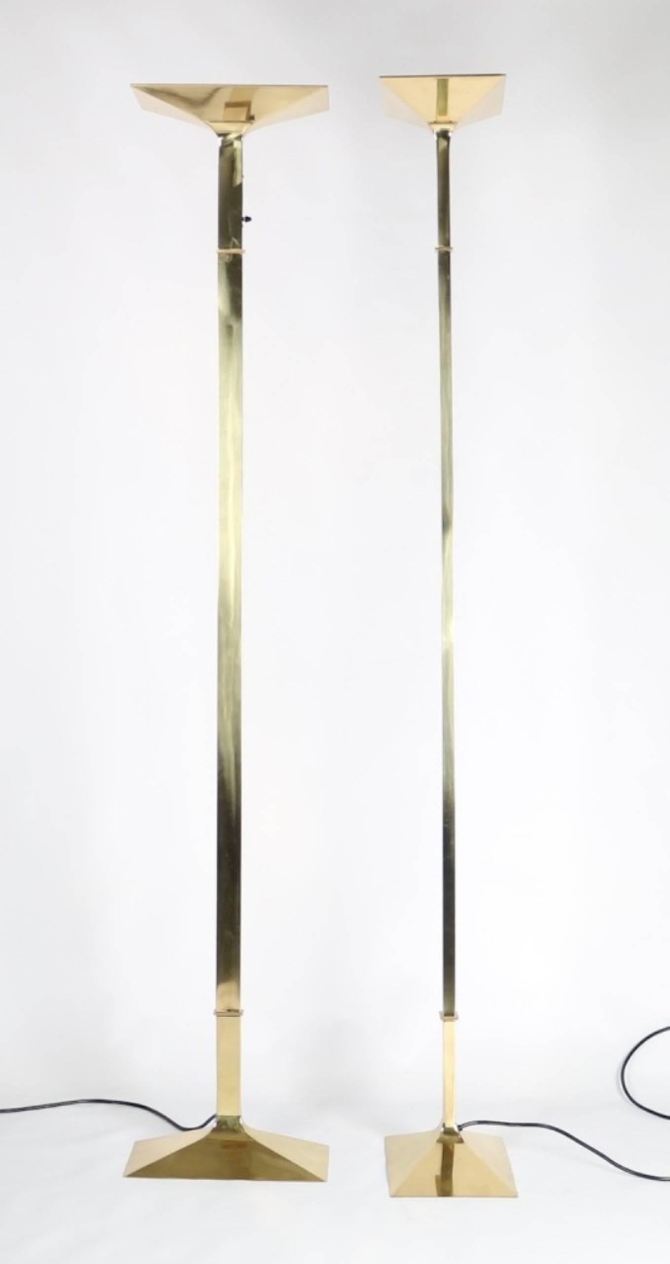 Italian Hollywood Regency brass torchiere floor lamps with dimmer. These lamps have been fully restored and include a halogen bulb. Each is in excellent vintage condition and has wear consistent with age and use.