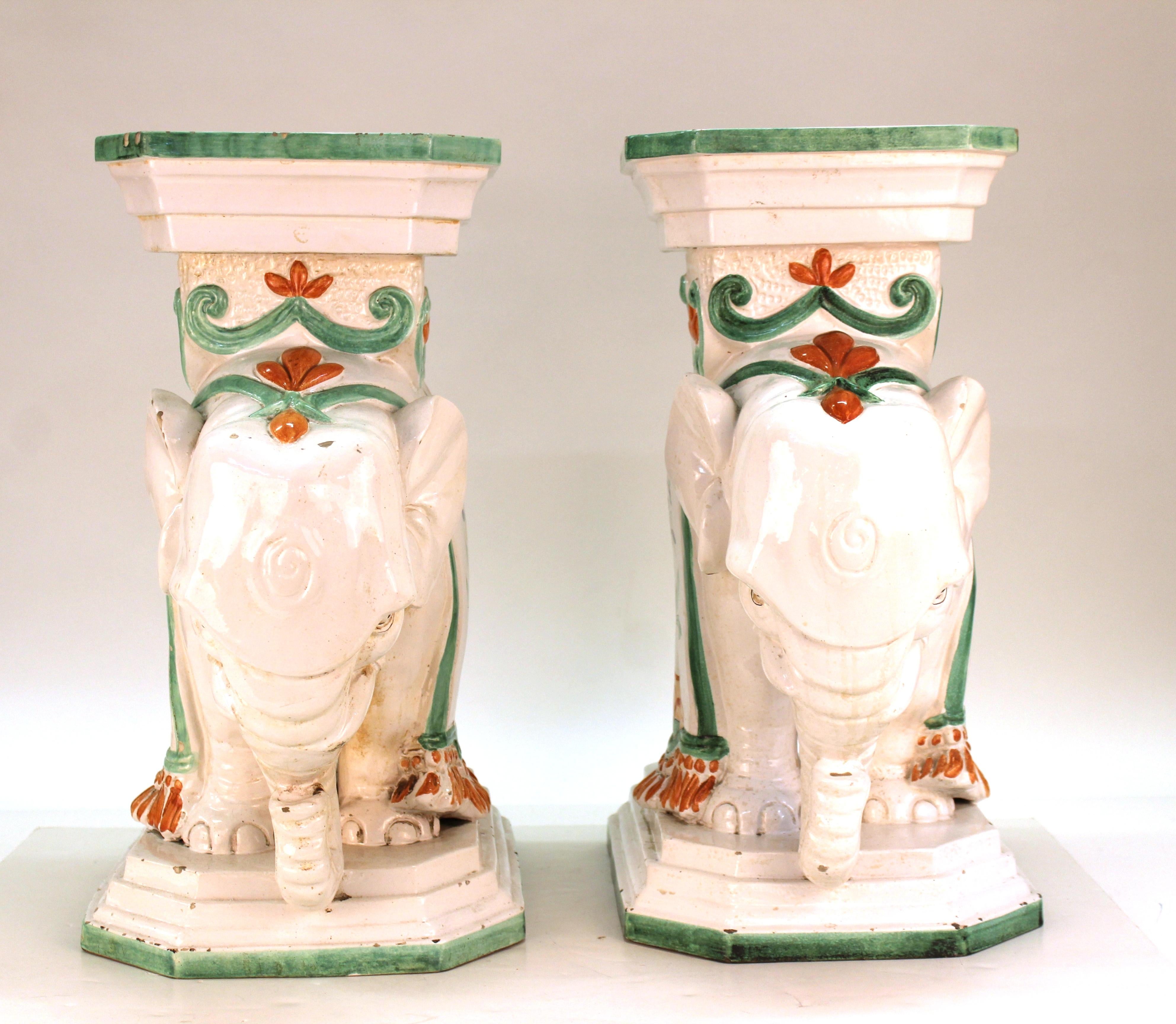 Hollywood Regency pair of hand-painted ceramic garden stools or pedestals in the shape of elephants. The pair is marked on the bottom and was made in Italy. Some minor chips to the surface, but overall in good vintage condition.
