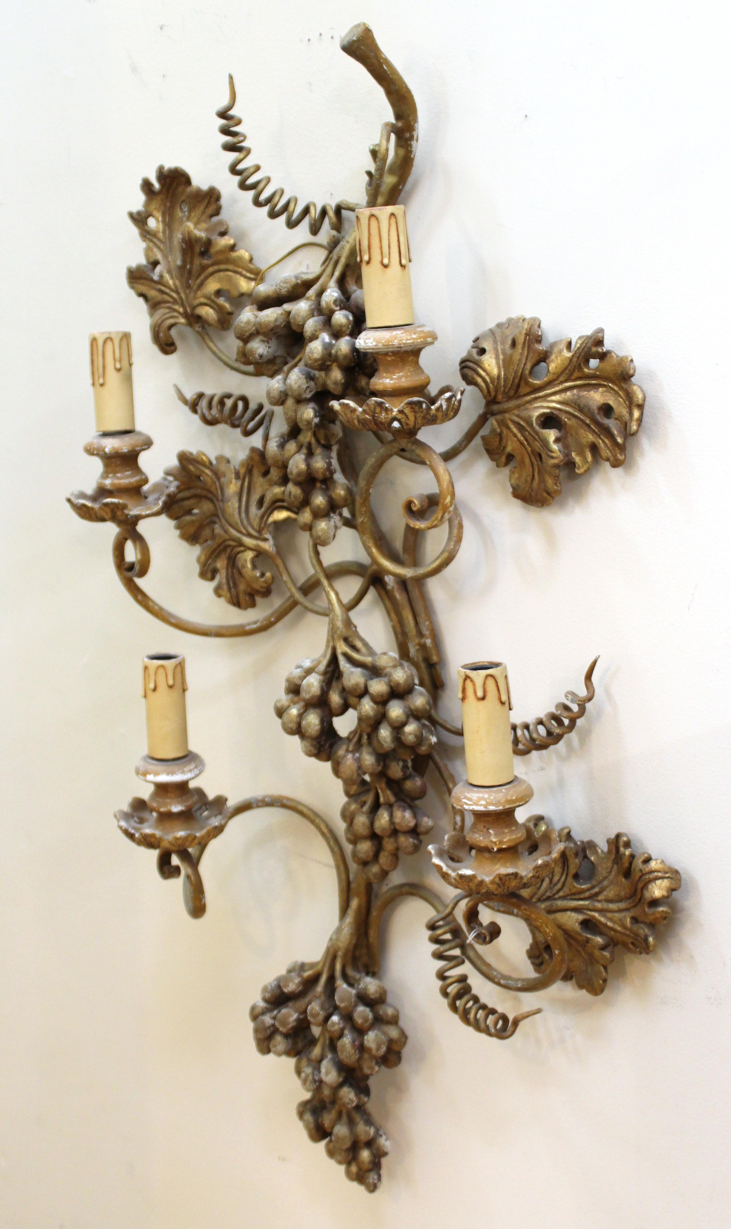 Italian Hollywood Regency wall sconce with a Florentine grapes style, made in the mid-1950s in Italy with wood and hand painted plaster. The piece has four light sources and is in great vintage condition with age-appropriate wear to the plaster and