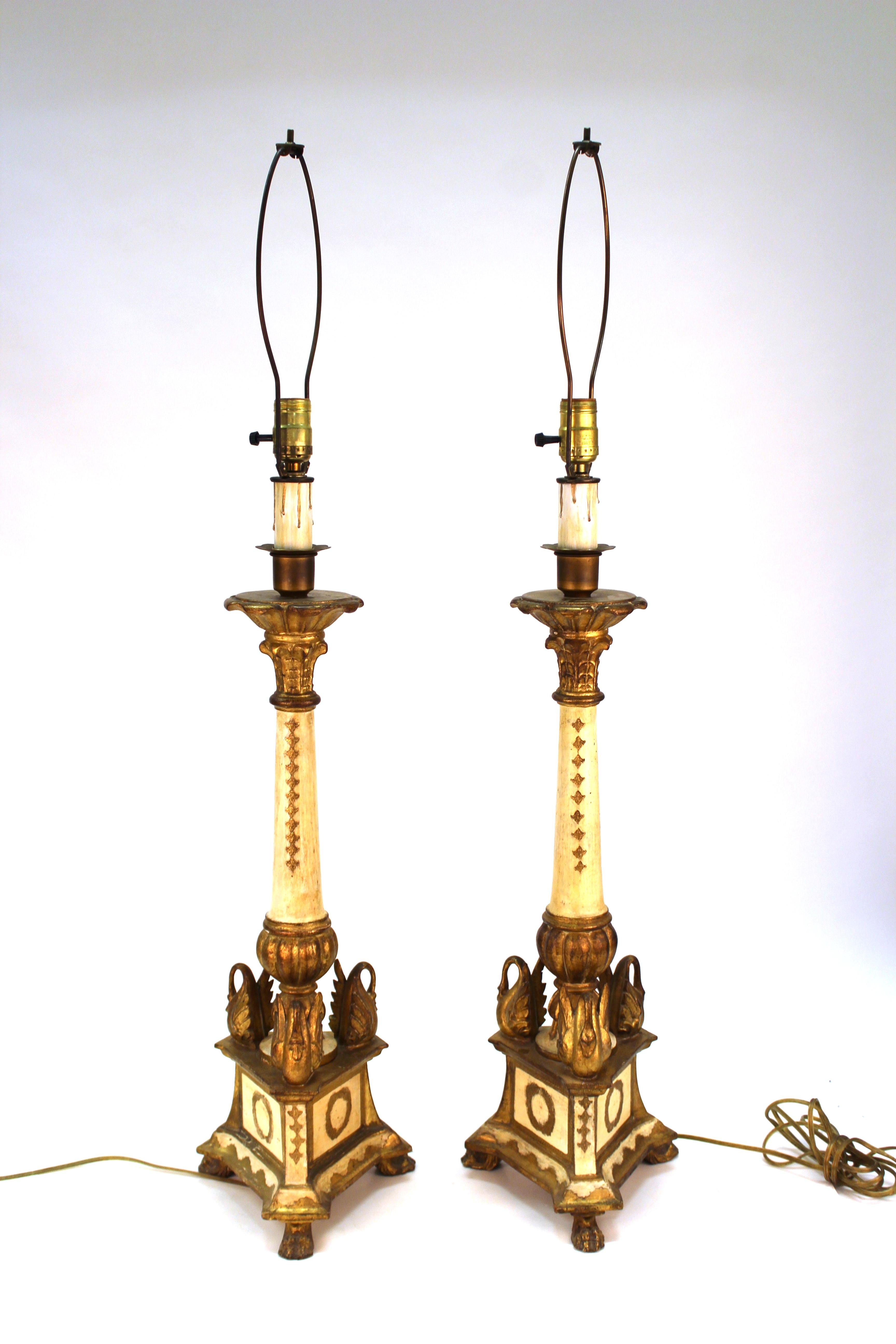 Italian Hollywood Regency pair of Florentine partially gilt wooden table lamps with elaborate ornaments and sculpted swans. The pair was made in Italy in the 1950s and has been recently rewired to fit current standards. In very good vintage