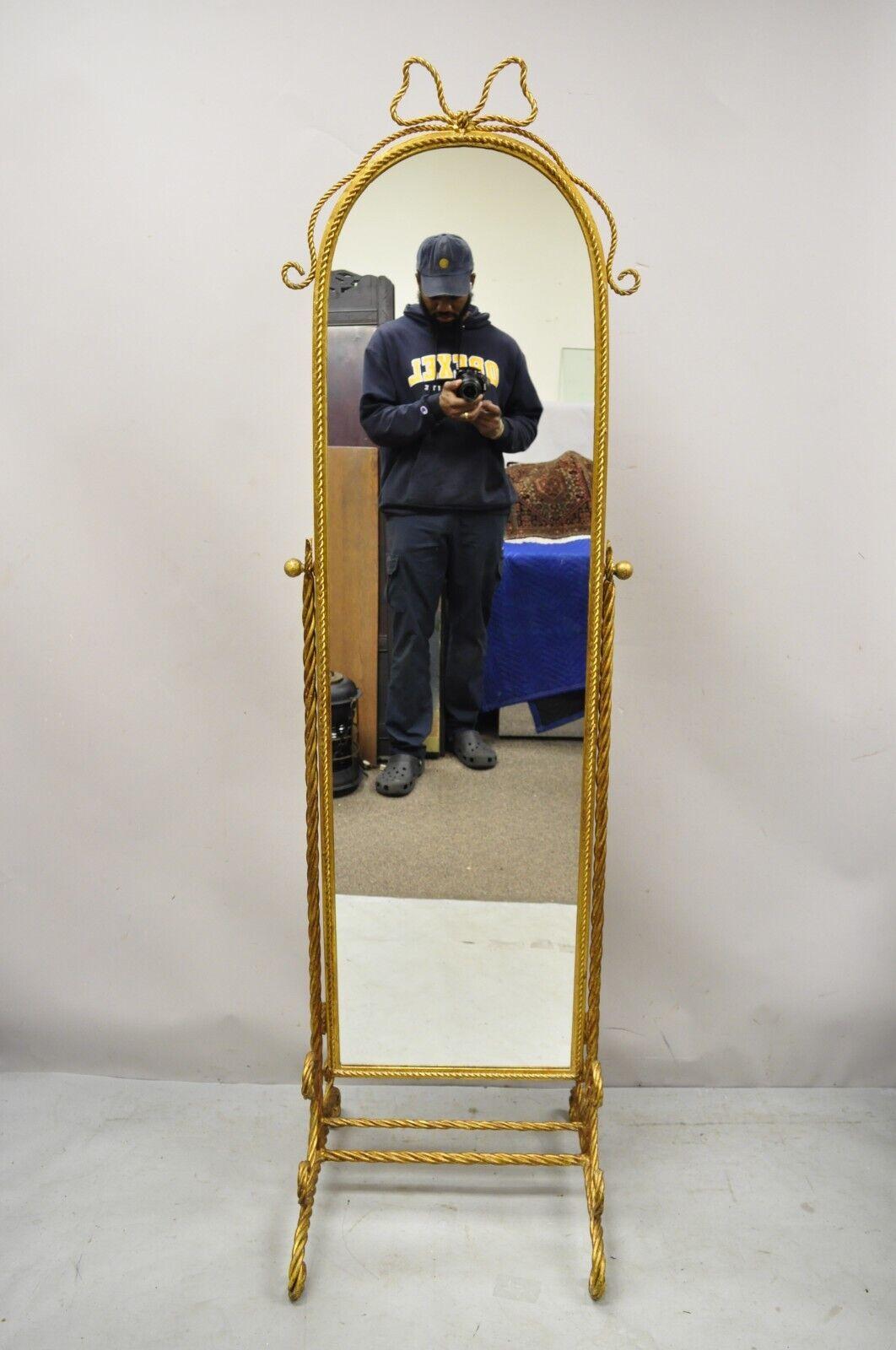 Italian Hollywood Regency Gold Gilt Iron Rope Cheval Standing Floor Mirror. Item features rope form iron frame, ribbon to crest of mirror, tall stately form. Circa Mid 20th Century. Measurements: 72.5