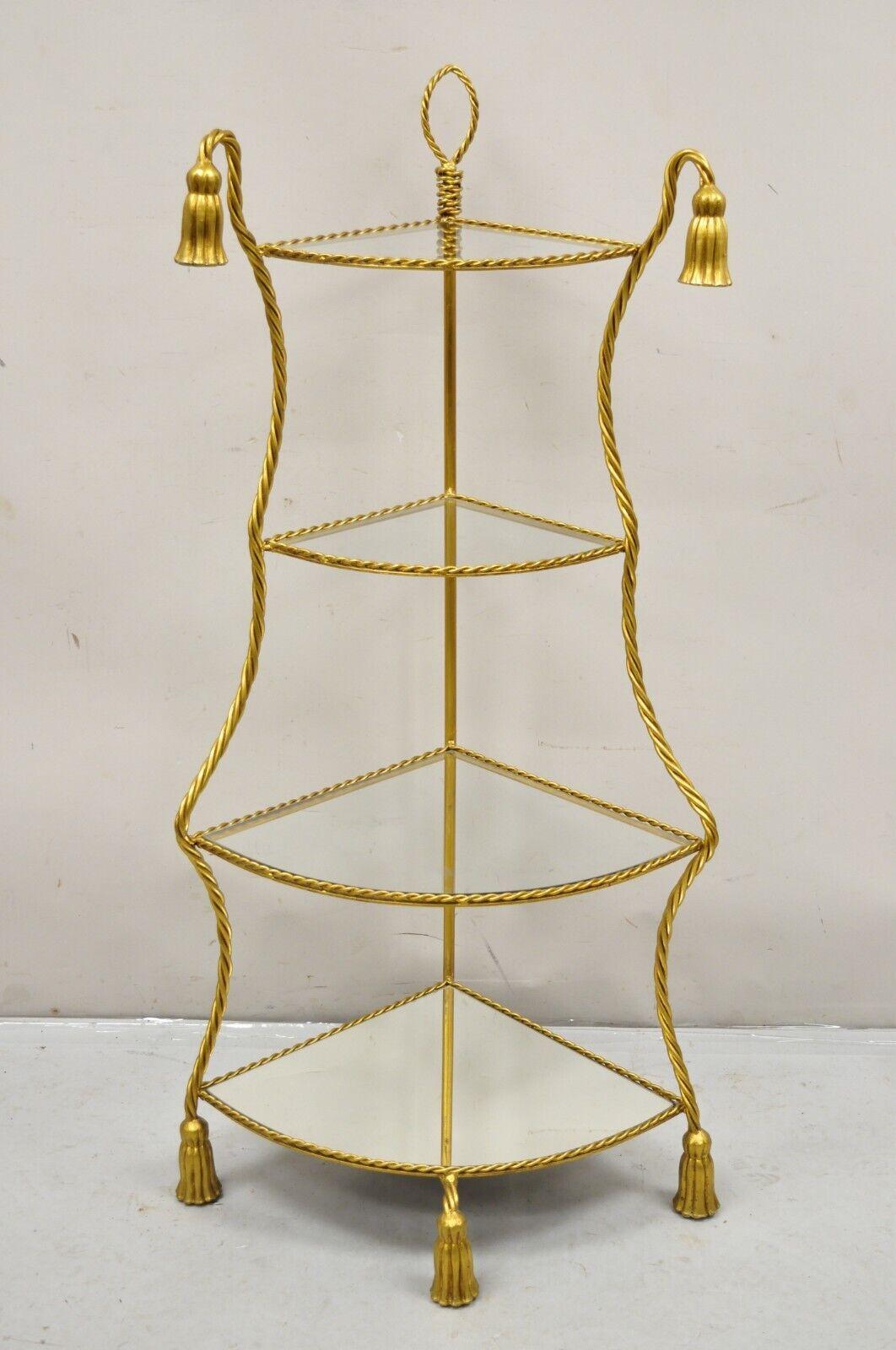 Italian Hollywood Regency Gold Gilt Iron Rope Tassel 4 Tier Etagere Corner Shelf. Item features a  mirror lower shelf, 3 clear glass upper shelves, wrought iron construction, gold gilt finish, vert nice vintage item. Circa Mid to Late 20th Century.