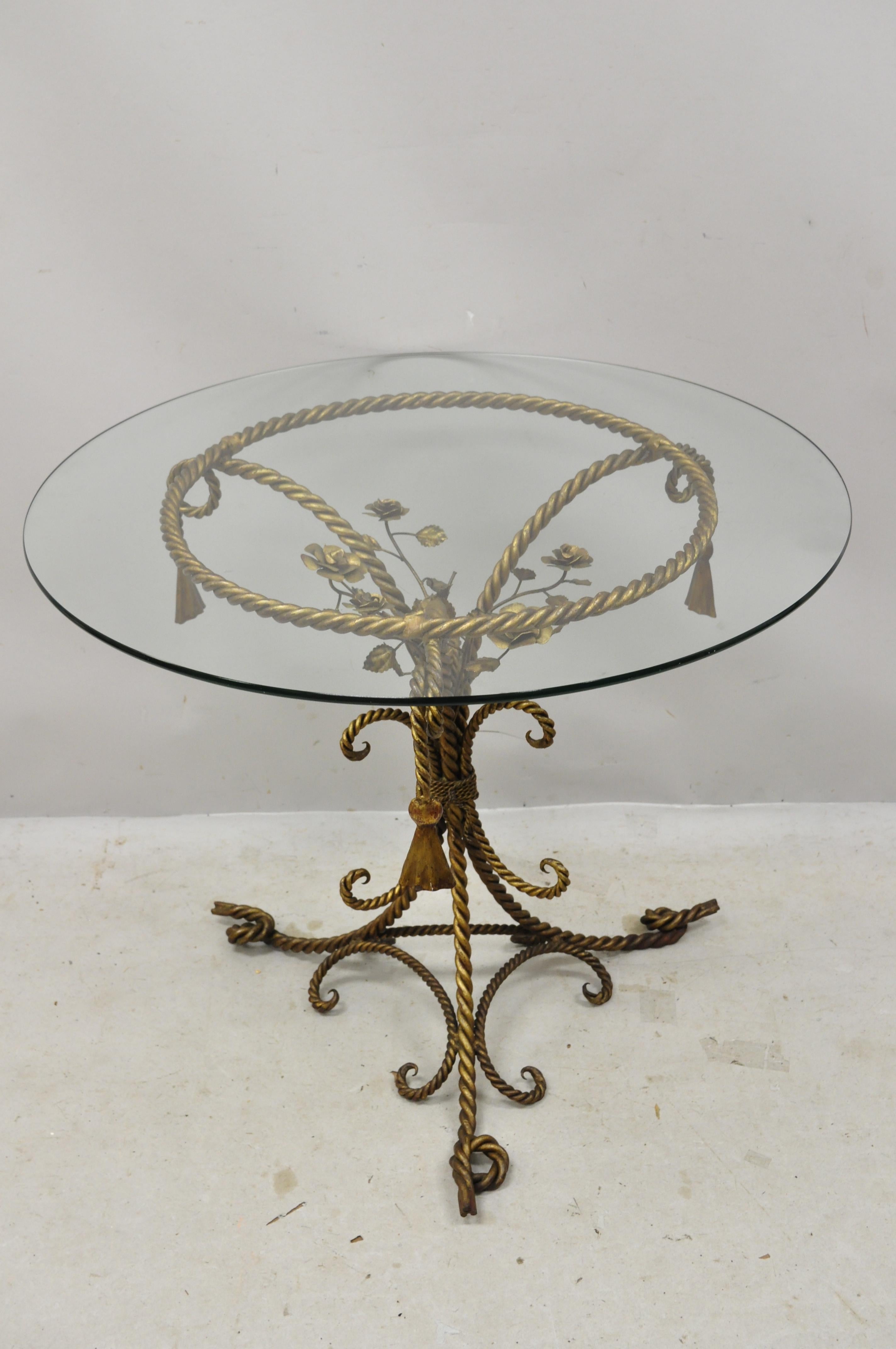 Italian Hollywood Regency gold gilt iron rope and tassel glass top center table. Item features heavy iron rope and tassel form pedestal base, round glass top, very nice vintage item, great style and form, circa early to mid-1900s.
Measurements: 30