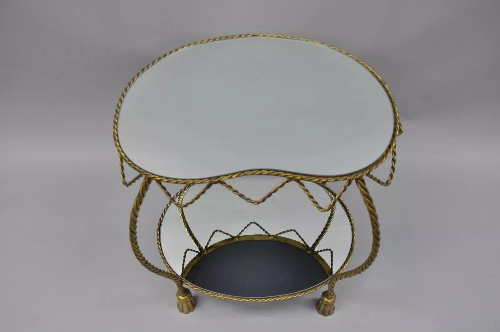 Table d'appoint à miroir en forme de rein, avec corde et glands, de style Hollywood Regency italien. L'article comporte une étiquette d'origine, un style et une forme remarquables, un miroir de forme rénale en haut, un miroir ovale en bas, une