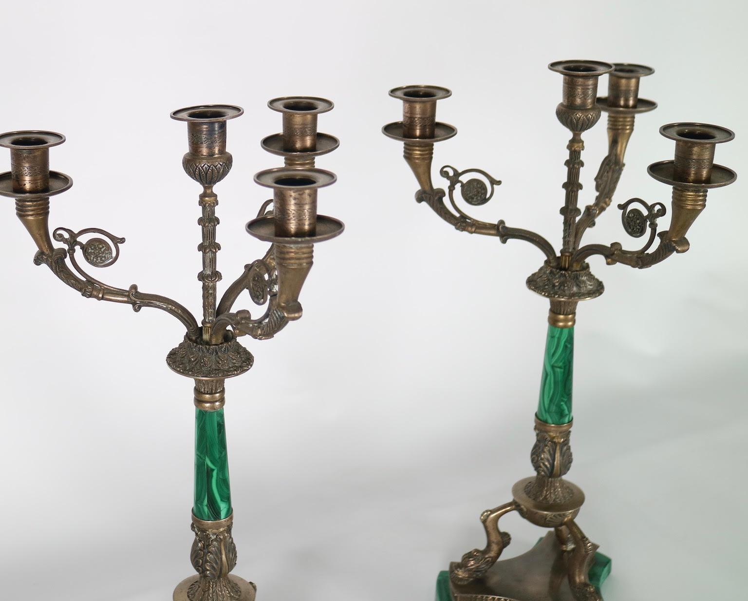 Pair of Italian Hollywood Regency candelabras in silver plated metal with malachite stem and base. Each candelabra has three arms surrounding a central arm. The pair was made in Italy during the 1950s and is in excellent vintage condition with