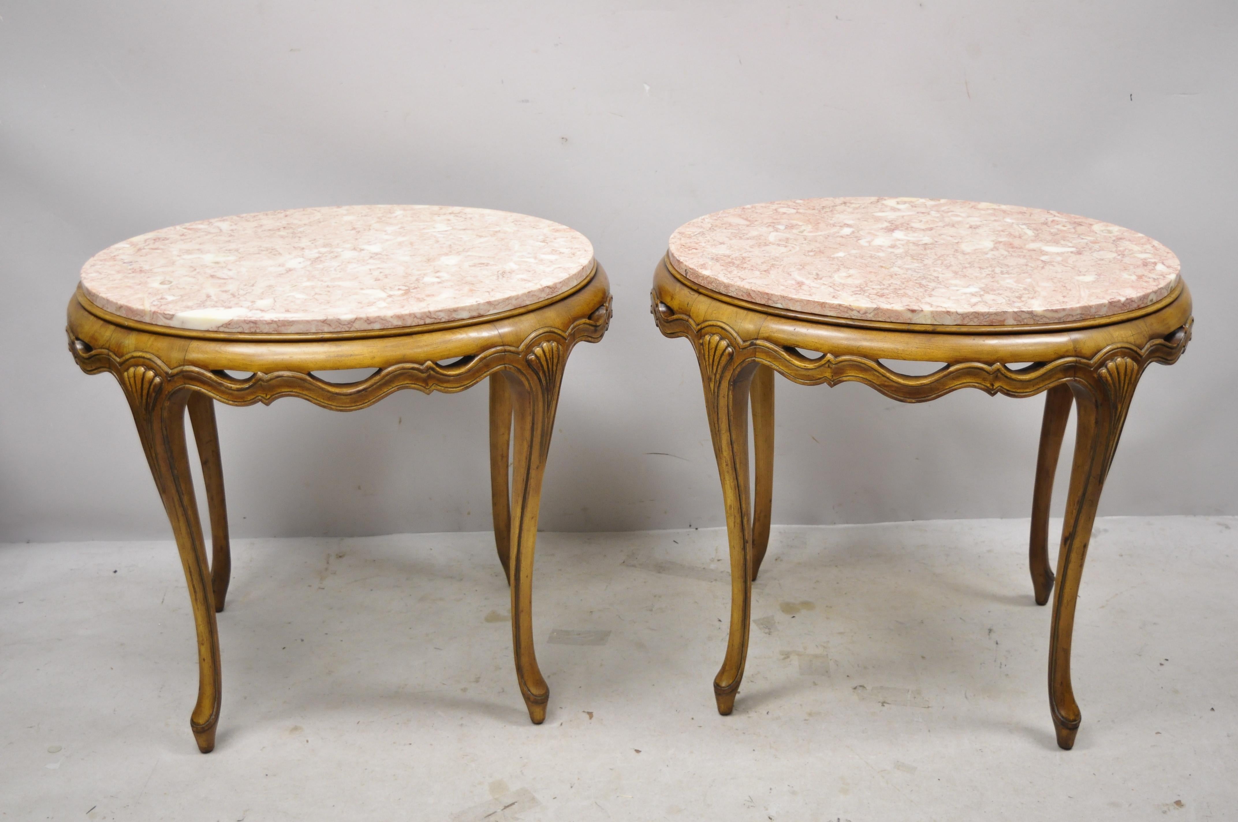 Vintage Italian Hollywood Regency pink oval marble-top pretzel carved side end tables, a pair. Item features pierce carved inter-woven skirt, pink oval marble tops, solid wood frame, cabriole legs, great style and form, circa mid-20th century.