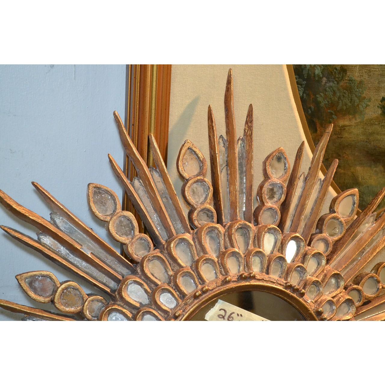 Outstanding 1940s Hollywood Regency style sunburst wall mirror. Handcrafted in Italy and featuring a circular center mirror and surrounded by two borders of small oval-shaped mirrors and radiant mirrored projections. 

Fantastic accent piece ideal