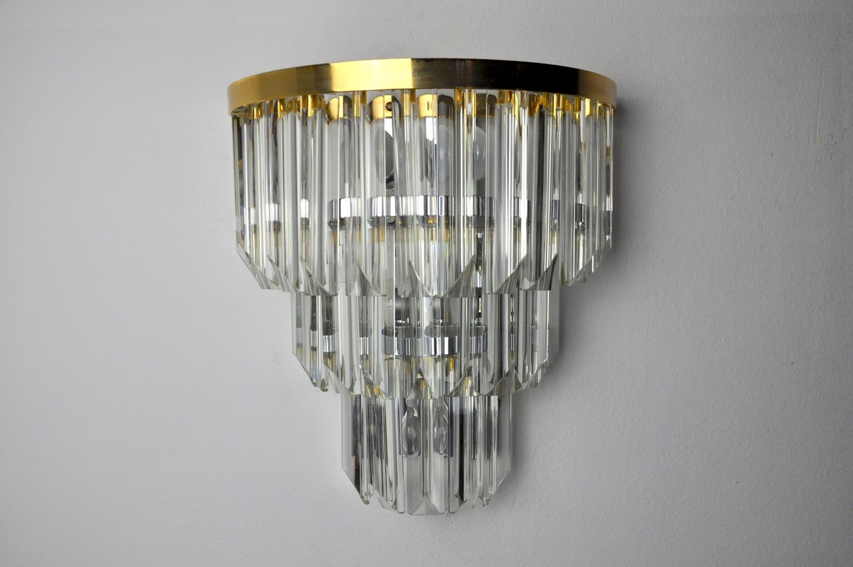 Very beautiful and small wall lamp from Venini dating from the 70s. Cut glass and golden metal structure. Unique object that will illuminate and bring a real design touch to your interior. Electricity verified, mark of time relative to the age of